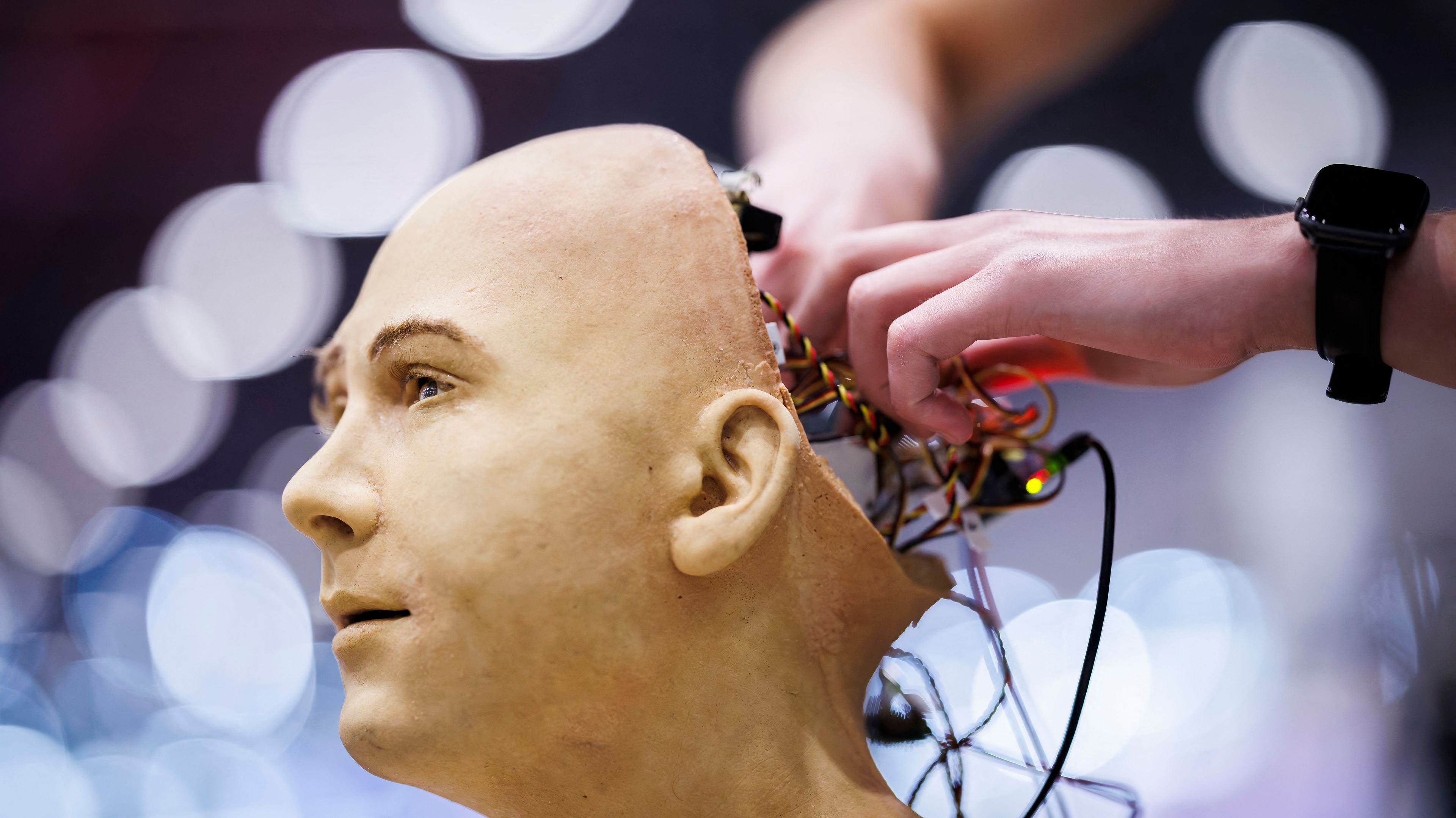 Ręce majstrujące w otwartej głowie robota.