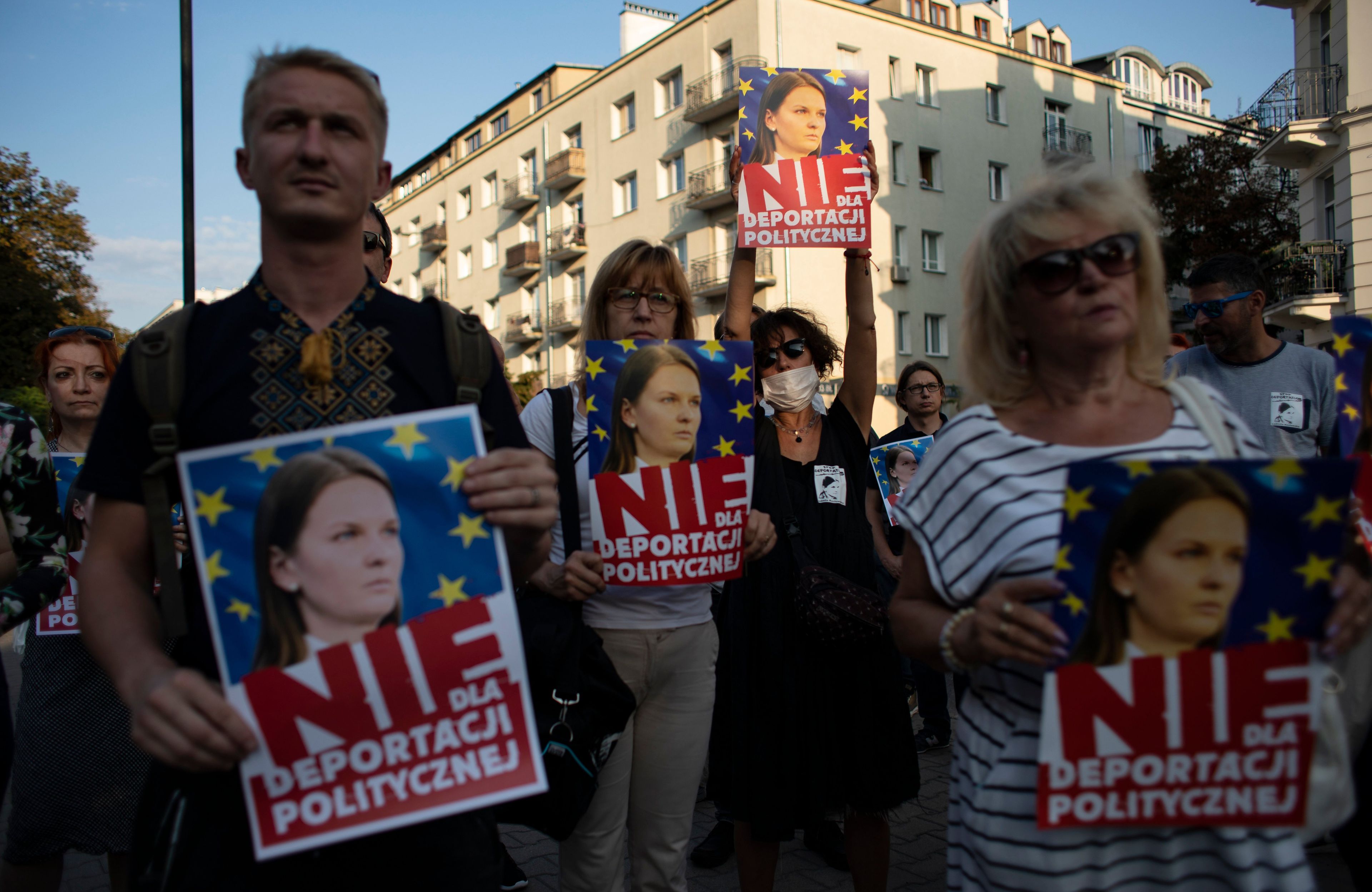 protestujący z plakatami przedstawiającymi młodą kobietę i napisem Nie