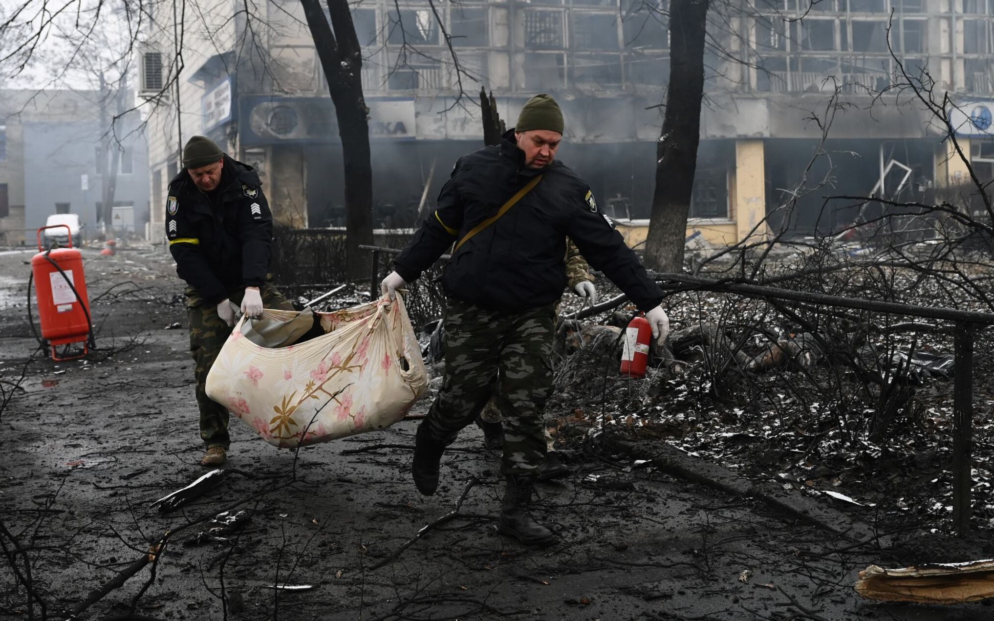 EDITORS NOTE: Graphic content / Police officers remove the body of a passerby killed in yesterday's airstrike that hit Kyiv's main television tower in Kyiv on March 2, 2022. - An apparent Russian airstrike hit Kyiv's main television tower in the heart of the Ukrainian capital on March 1, 2022. (Photo by ARIS MESSINIS / AFP)
