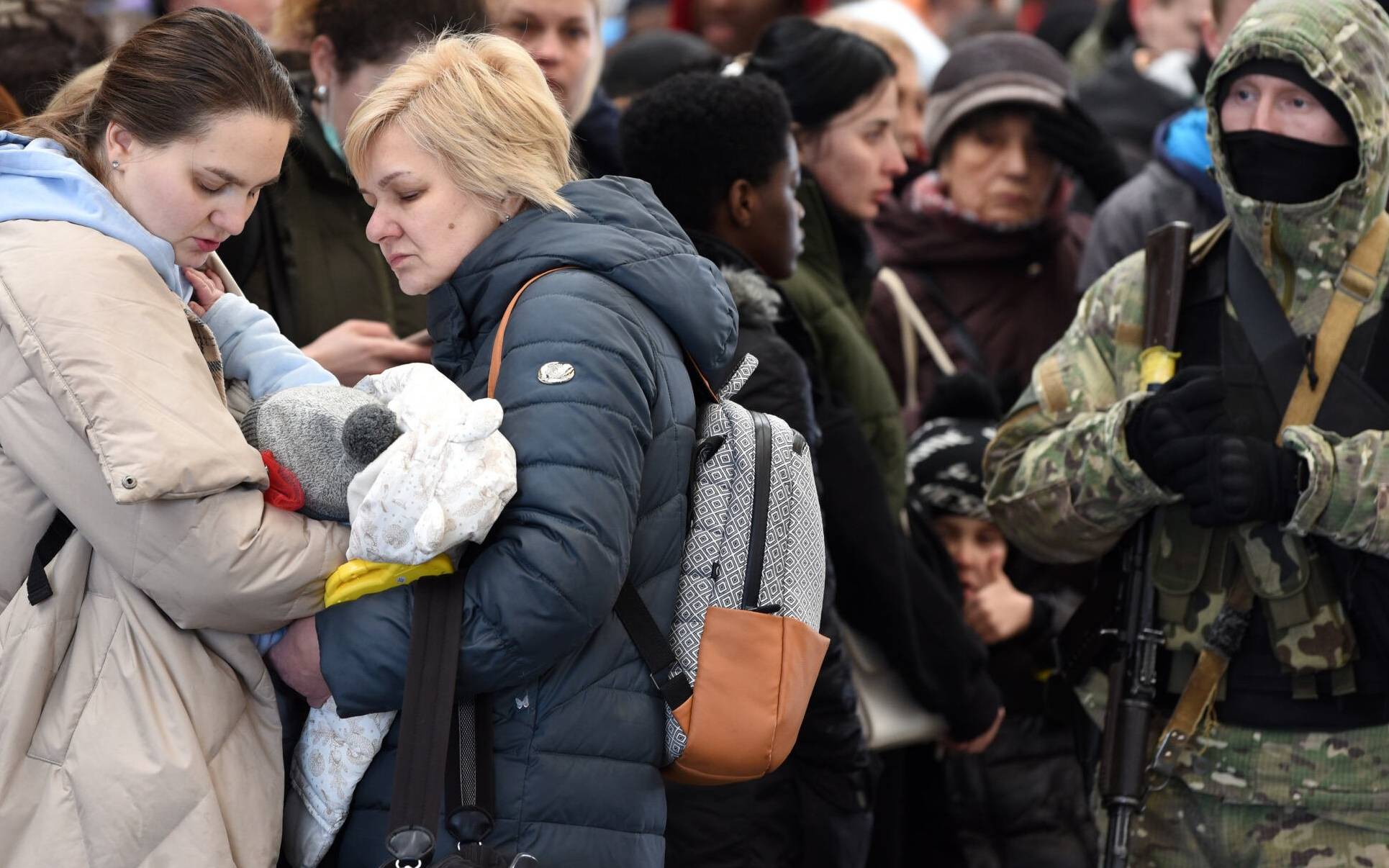 People wait for a train to Poland at the railway station of the western Ukrainian city of Lviv on February 26, 2022. - Ukrainian forces repulsed a Russian attack on Kyiv but "sabotage groups" infiltrated the capital, officials said on February 26 as Ukraine reported 198 civilians killed in Russia's invasion so far. A defiant Ukrainian President Volodymyr Zelensky vowed his pro-Western country would never give in to the Kremlin even as Russia said it had fired cruise missiles at military targets. (Photo by Yuriy Dyachyshyn / AFP)