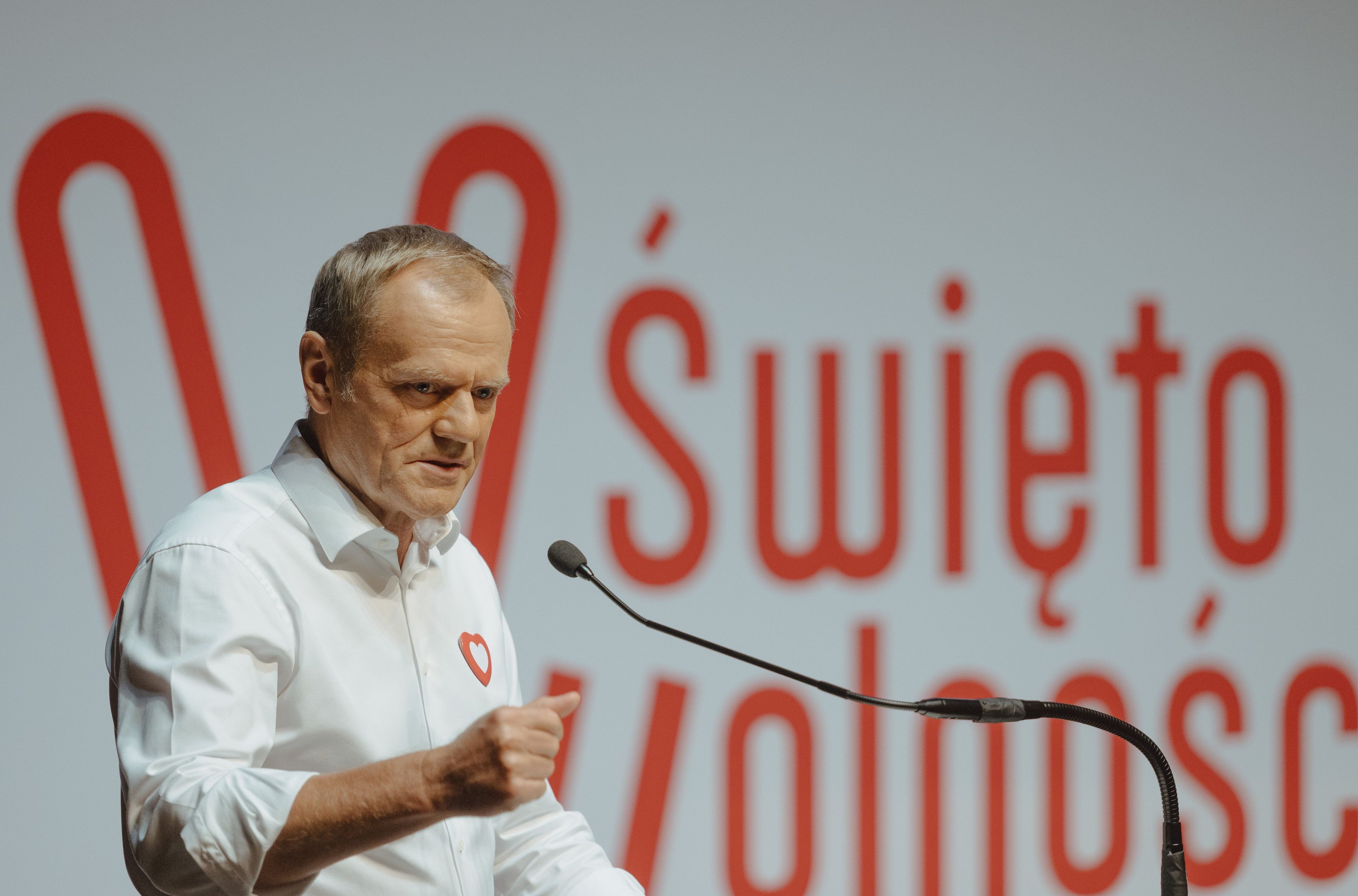 Mężczyzna w białej koszuli na tle napisu Święto wolności