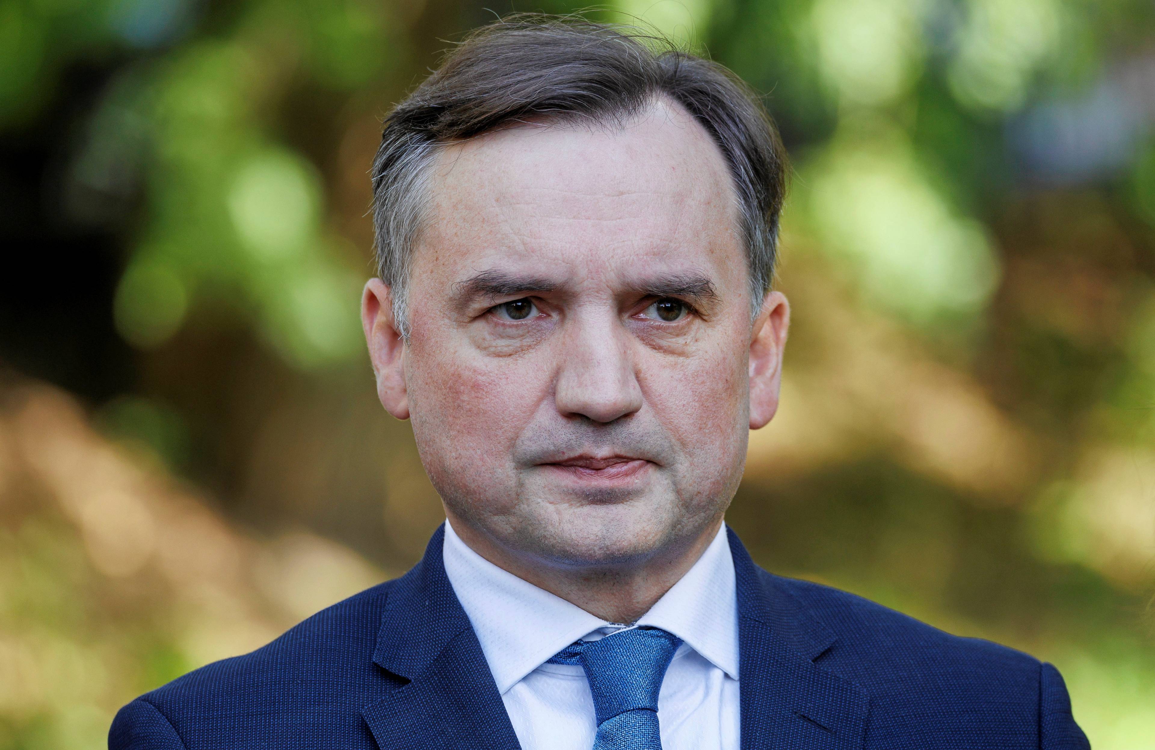 Mężczyzna stoi na tle drzew