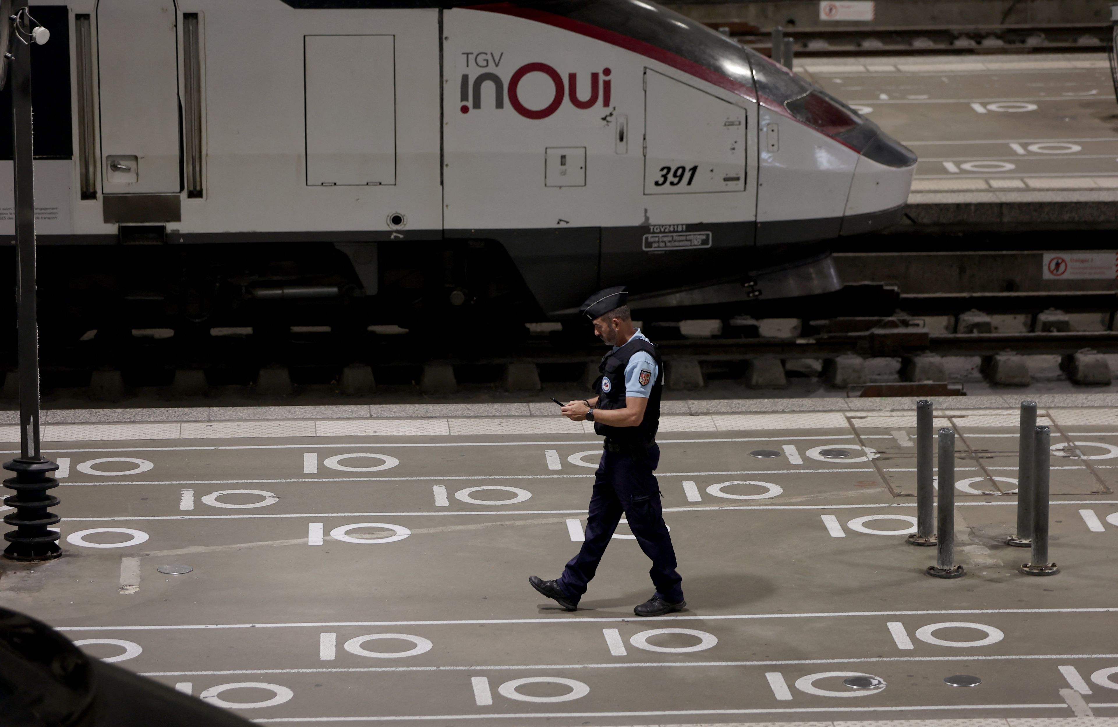policjant na peronie, w tle pociąg tgv