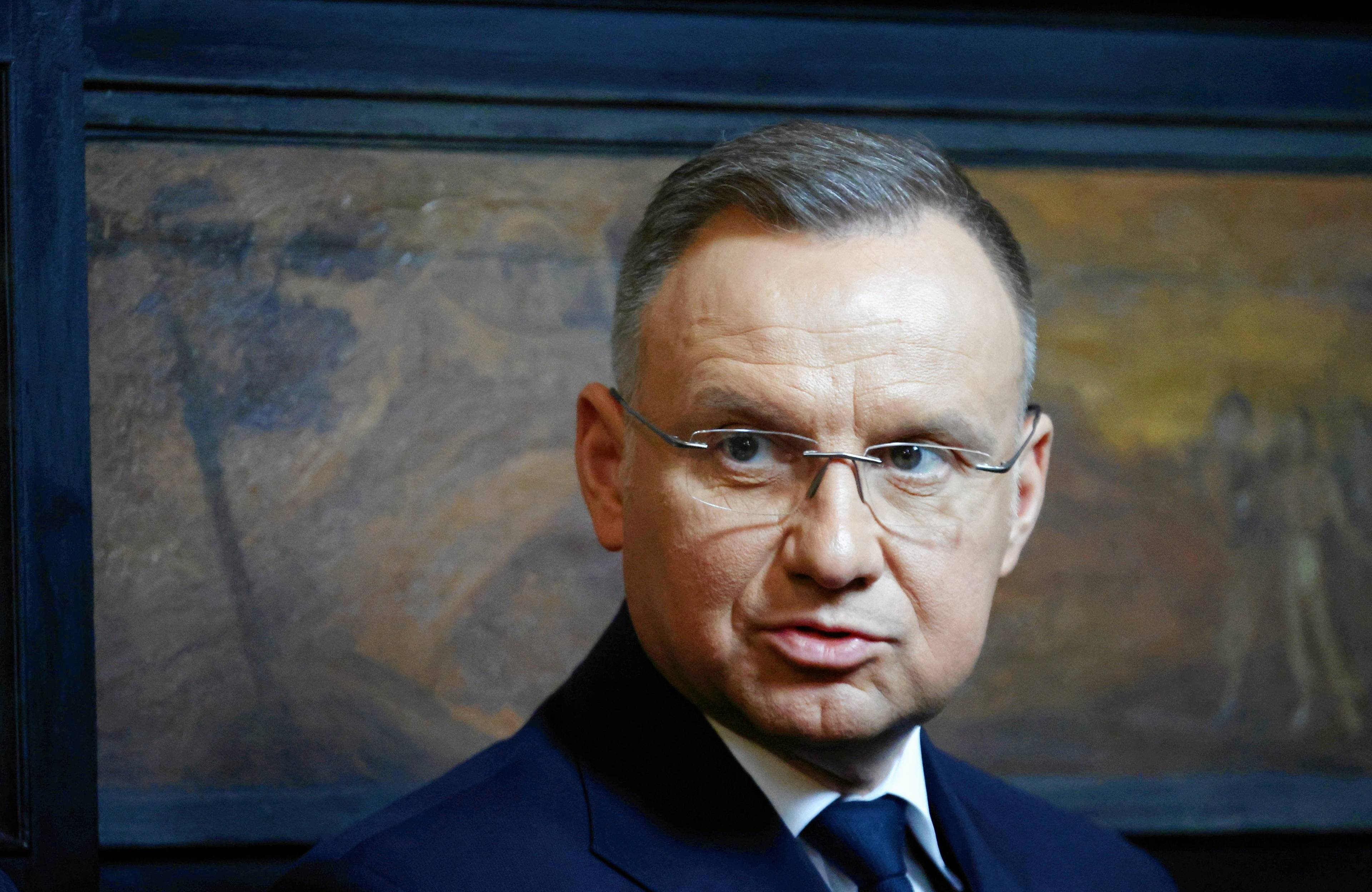 Portret Andrzeja Dudy w okularach i płaszczu. Prezydent spogląda w lewą stronę