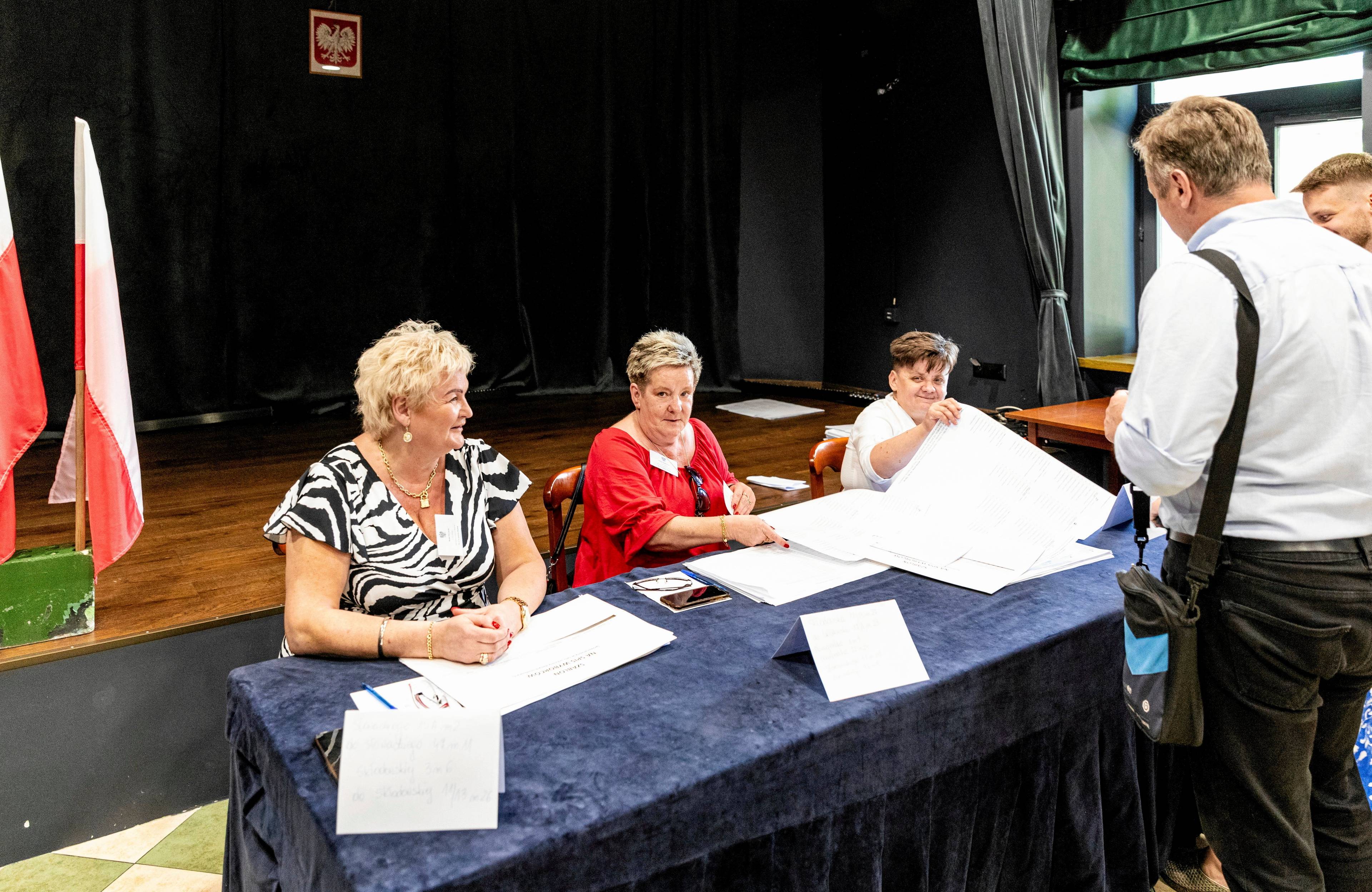 Trzy kobiety w obwodowej komisji wyborczej za stołem