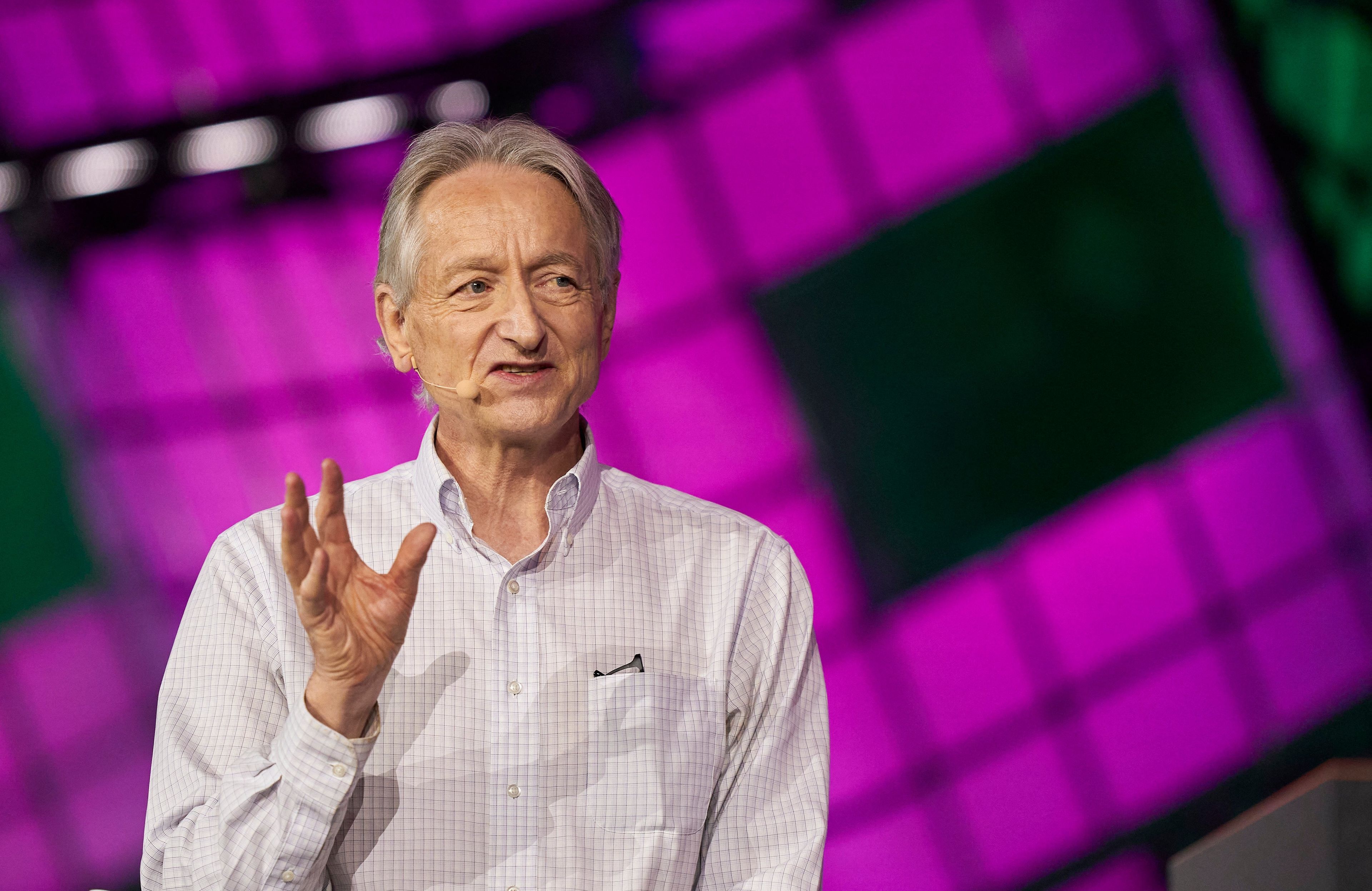 Geoffrey Hinton, siwy mężczyzna w białej koszuli przemawia na fioletowym tle
