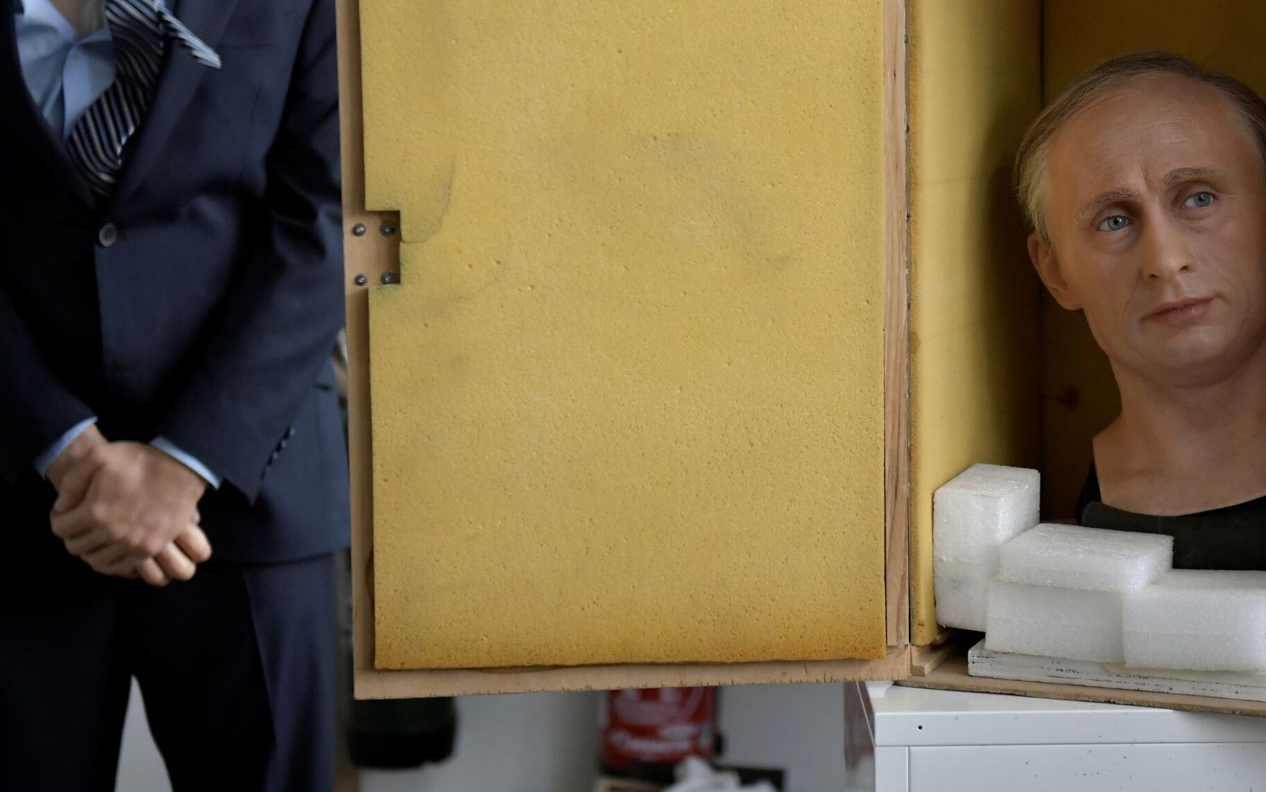 The wax statue of Russian President Vladimir Putin is being packed is a box before it is stored in the reseve, as a reaction to Russia's invasion of Ukraine on March 1, 2022 at the Grevin museum in Paris. (Photo by JULIEN DE ROSA / AFP)