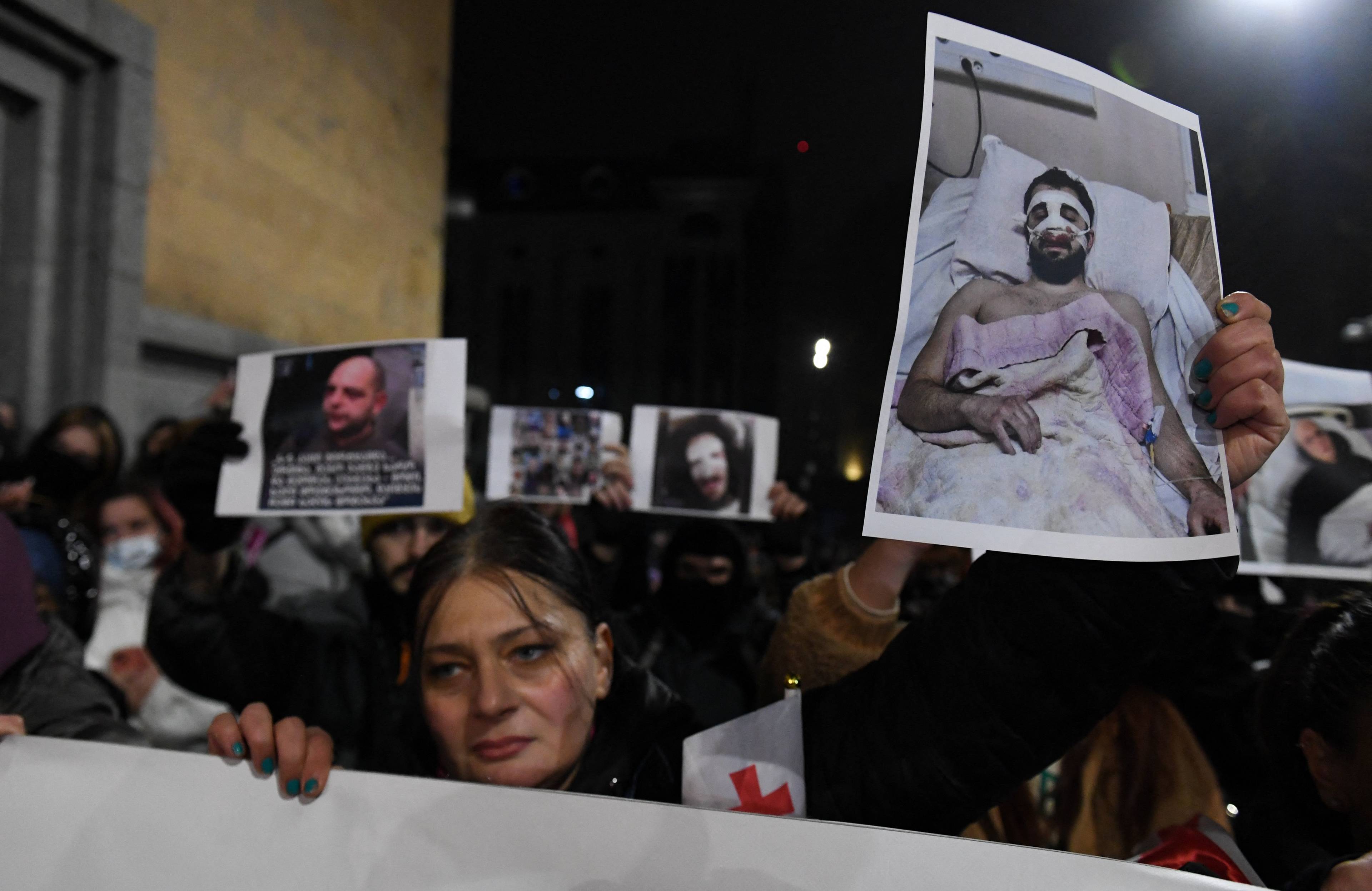 Protesty w Tbilis. Uczestnoicy trzymają w rękach zdjęcia osób zmasakrowanych przez policję. 7.12.2024 r.