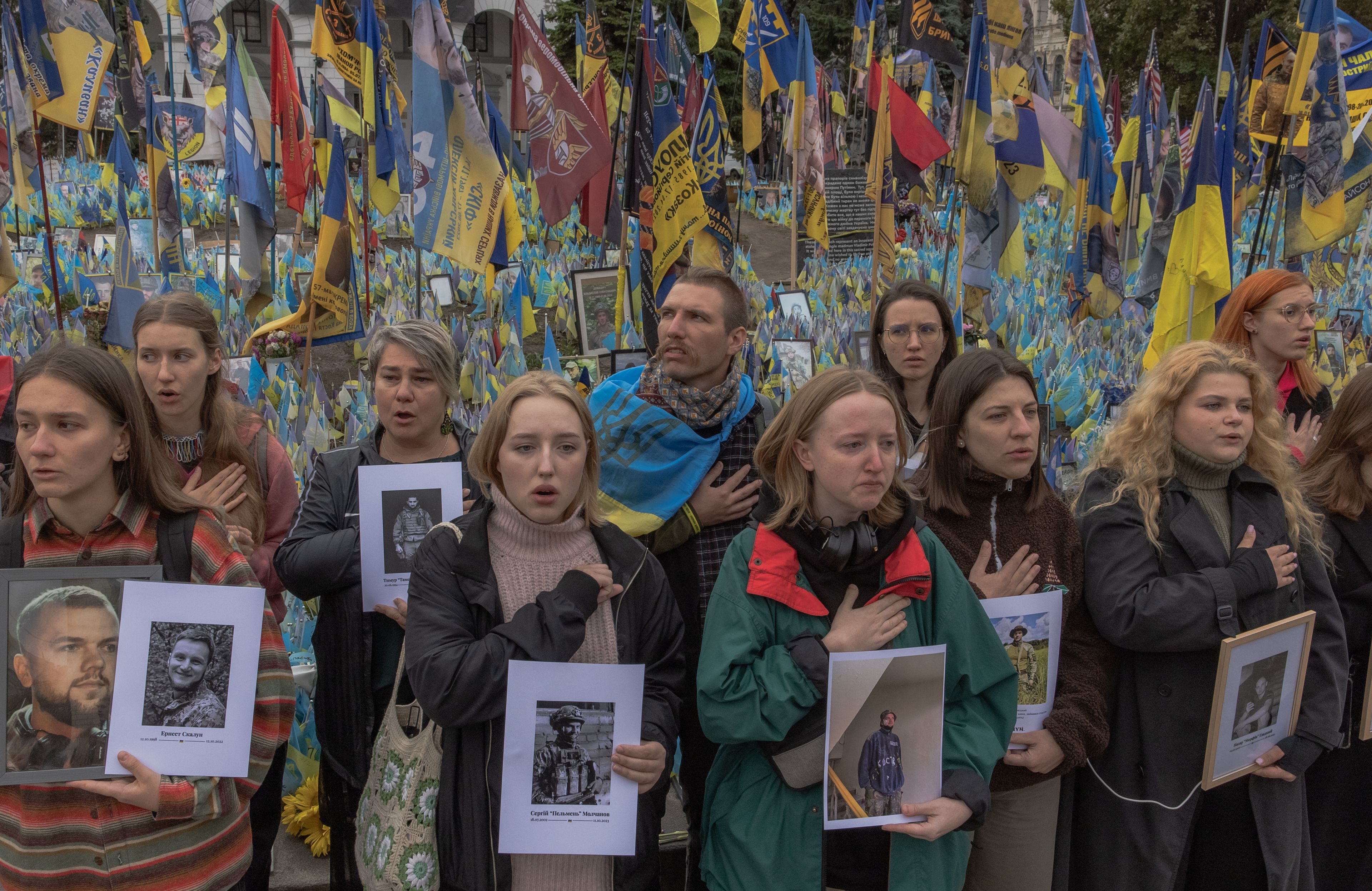 Młodzi ludzie z fotografiami zabitych żołnierzy i żołnierek