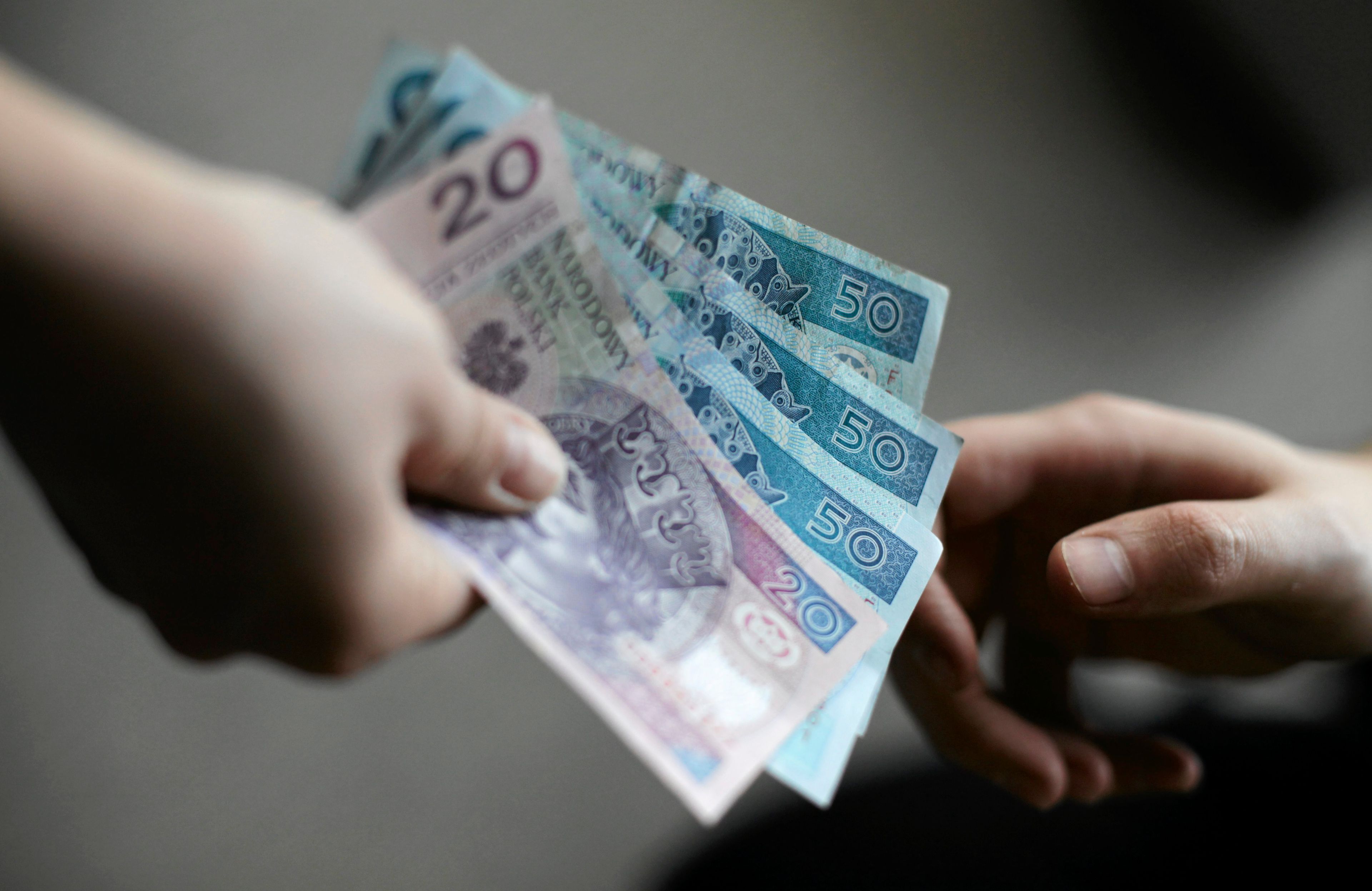 Dłoń wręczająca banknoty