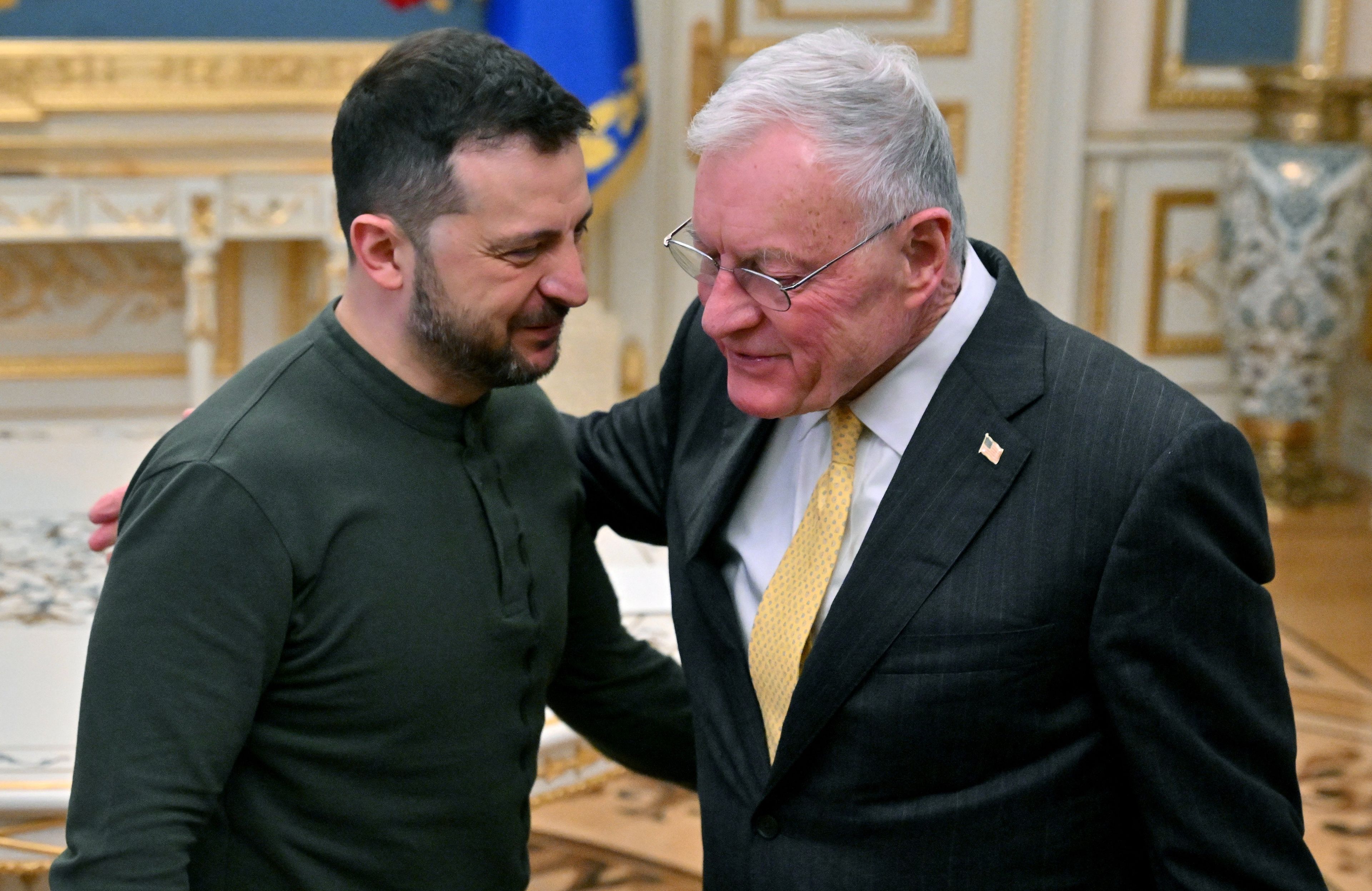 Na zdjęciu dwóch mężczyzna w zielonej wojskowej bluzie (prezydent Ukrainy Wołodymyr Zełenski) i mężczyzna w garniturze i żółtym krawacie (generał Keith Kellogg) obejmują się w przyjaznym geście