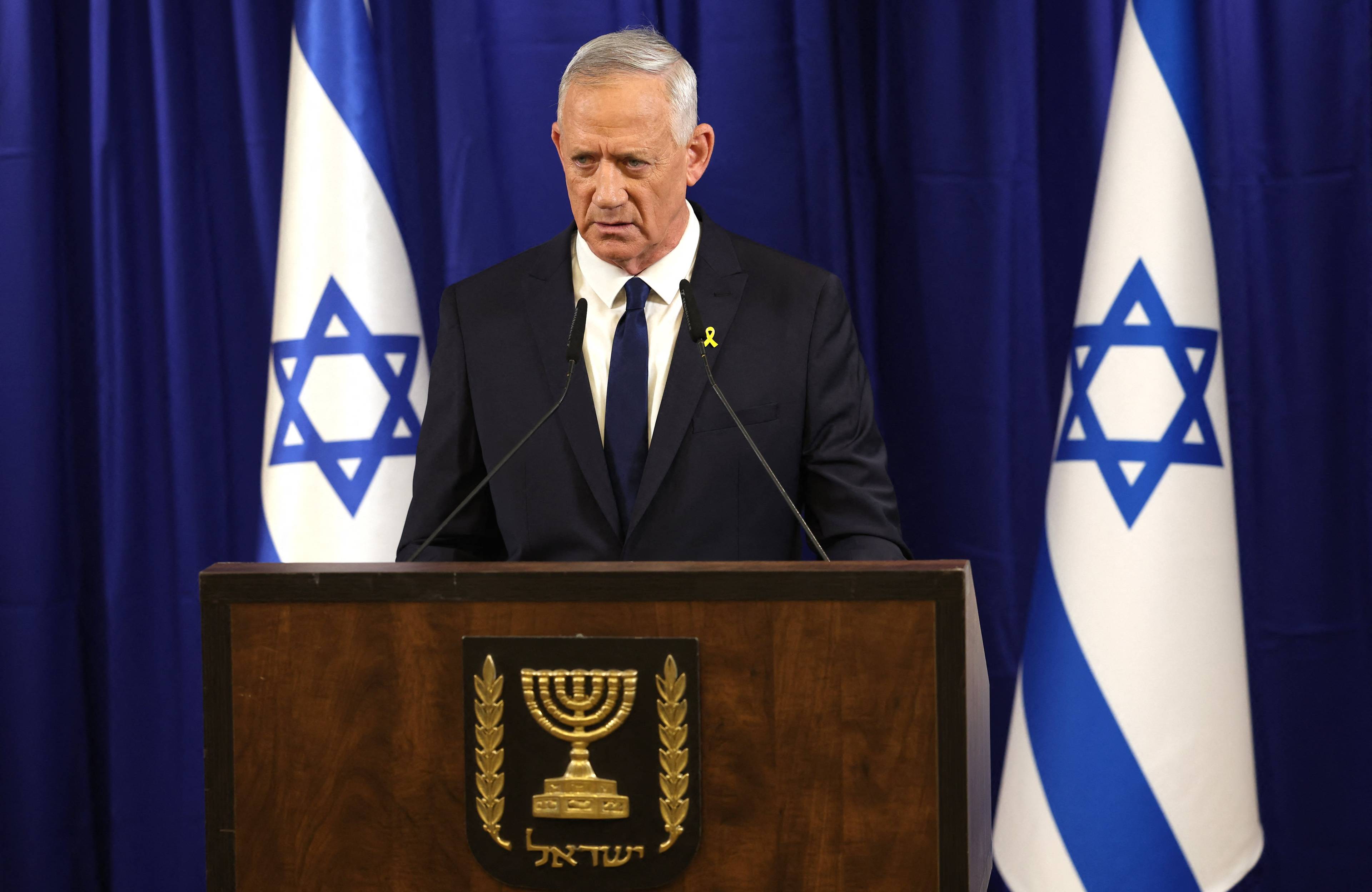 Minister Beni Ganc podczas konferencji, na której ogłosił rezygnację z rządu. W tle flagi Izraela