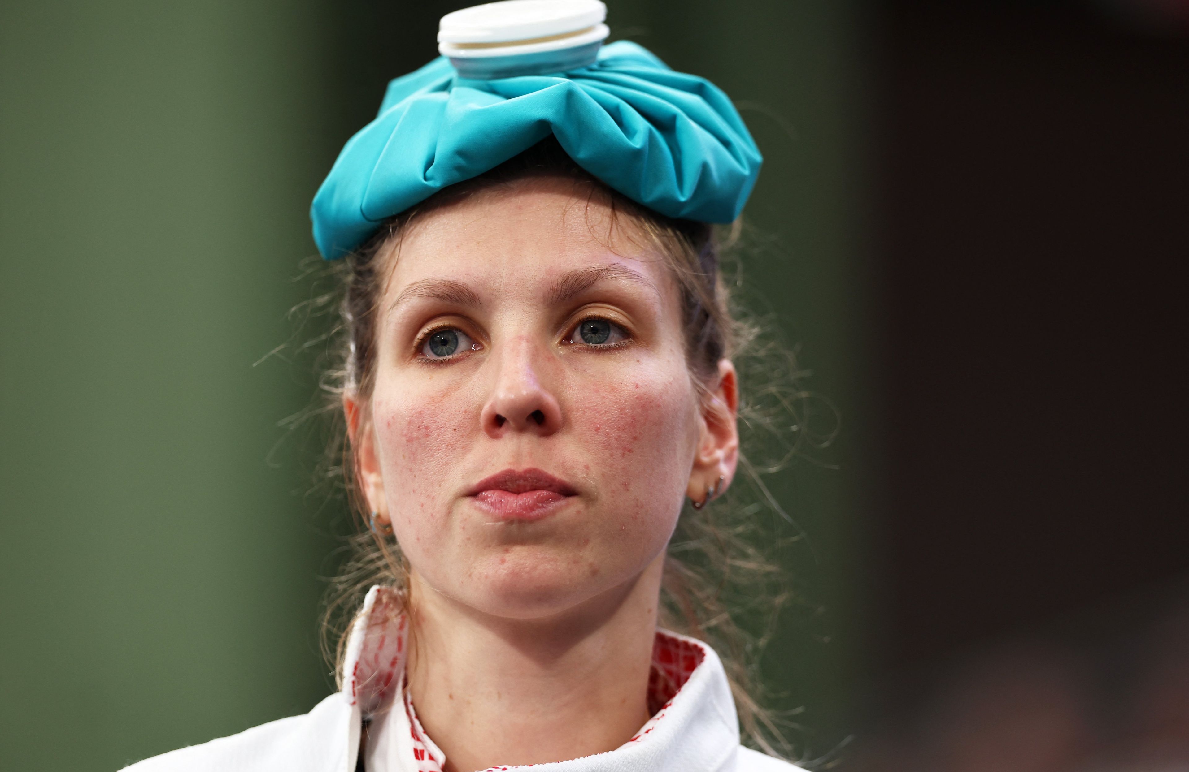France's Auriane Mallo-Breton looks on with an ice pack on her head, in the women's team epee bouts during the Paris 2024 Olympic Games, at the Grand Palais in Paris, on July 30, 2024. (Photo by Franck FIFE / AFP)