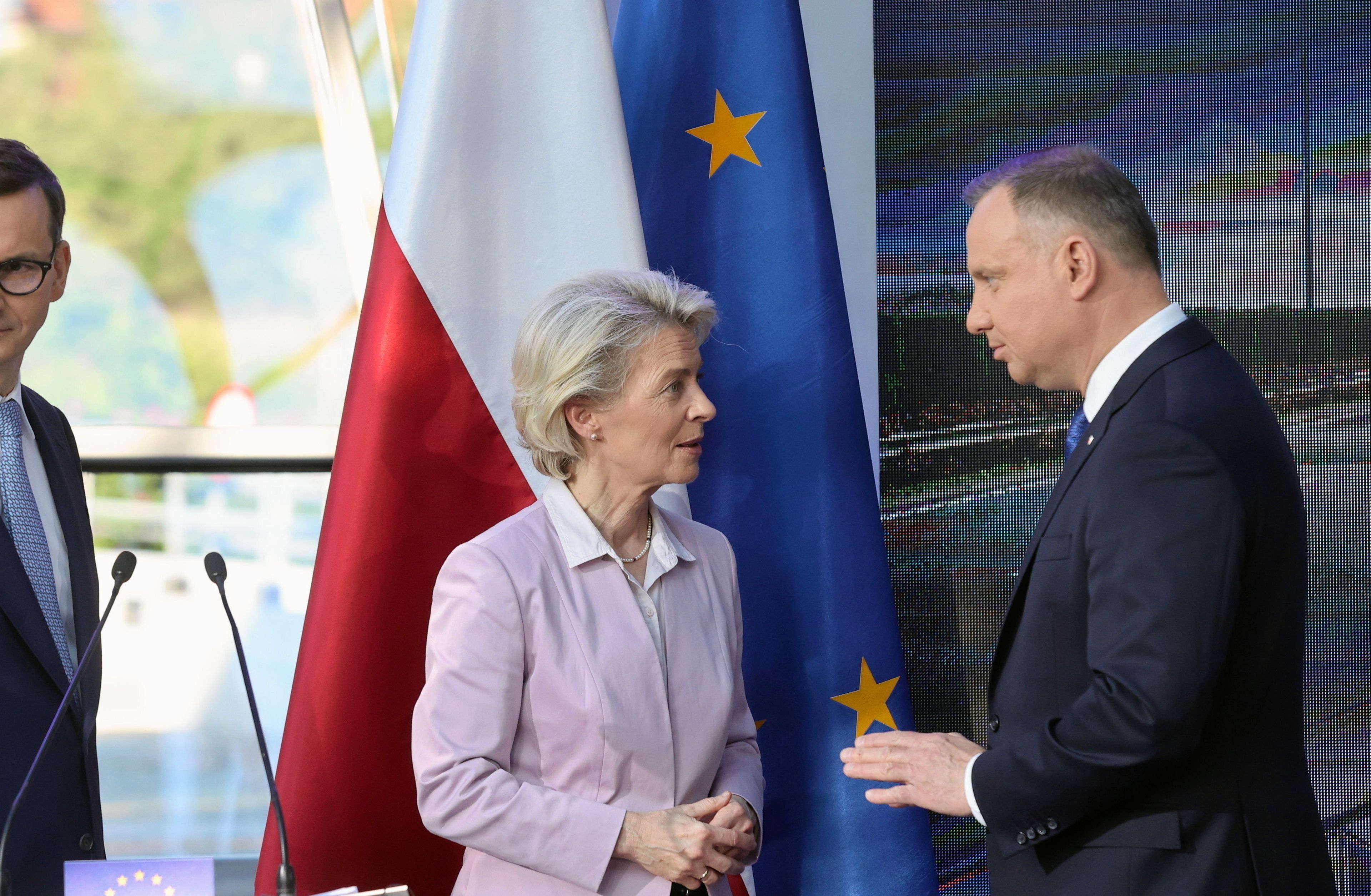 Premier Morawiecki, URsula von der Leyen i prezydent Duda rozmawiają. Przed nimi mównica, za nimi flagi Polski oraz Unii Europejskiej