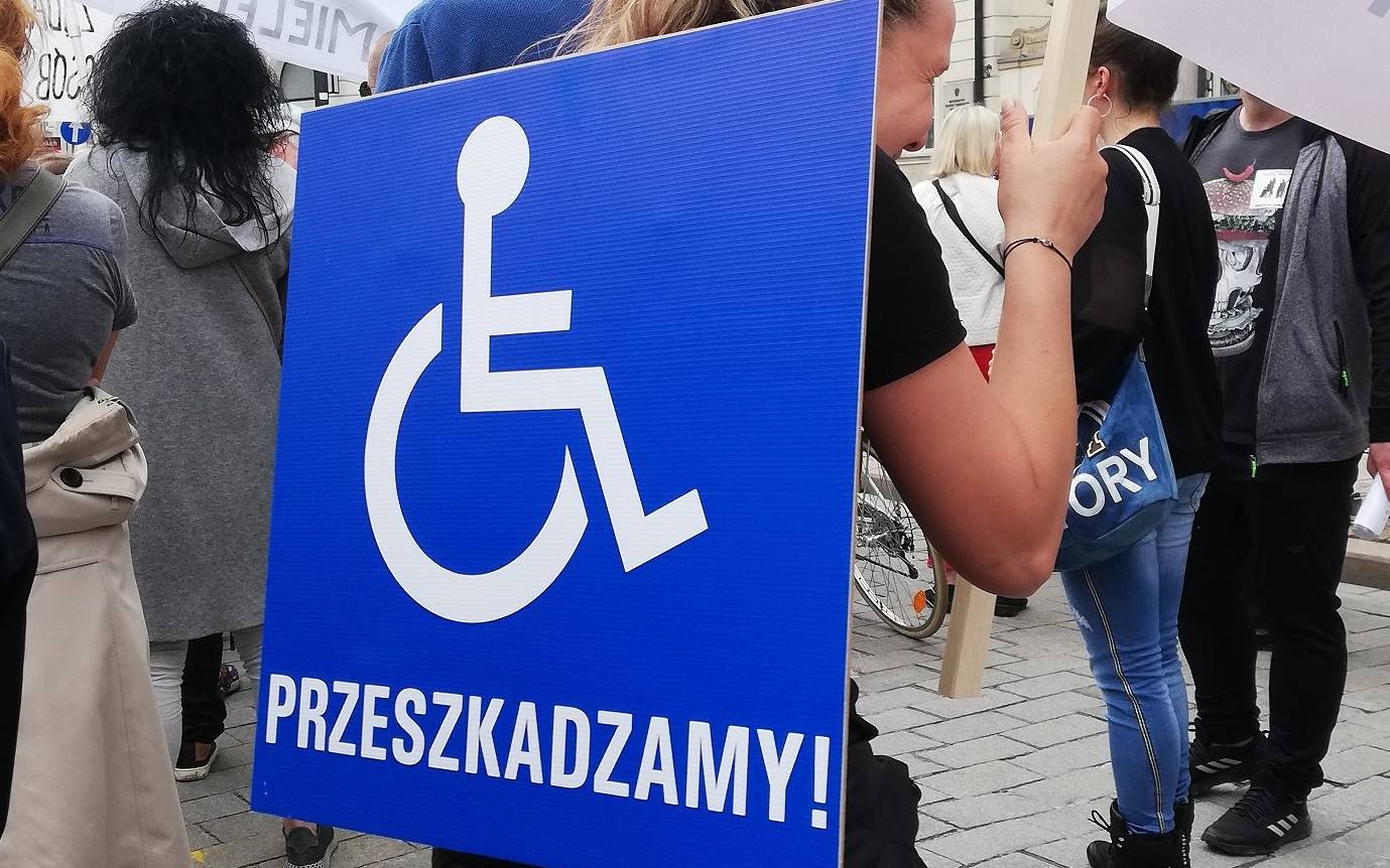 Grafika do artykułu Rocznica protestu rodzin osób z niepełnosprawnością. Kancelaria Premiera ignoruje stojących w deszczu