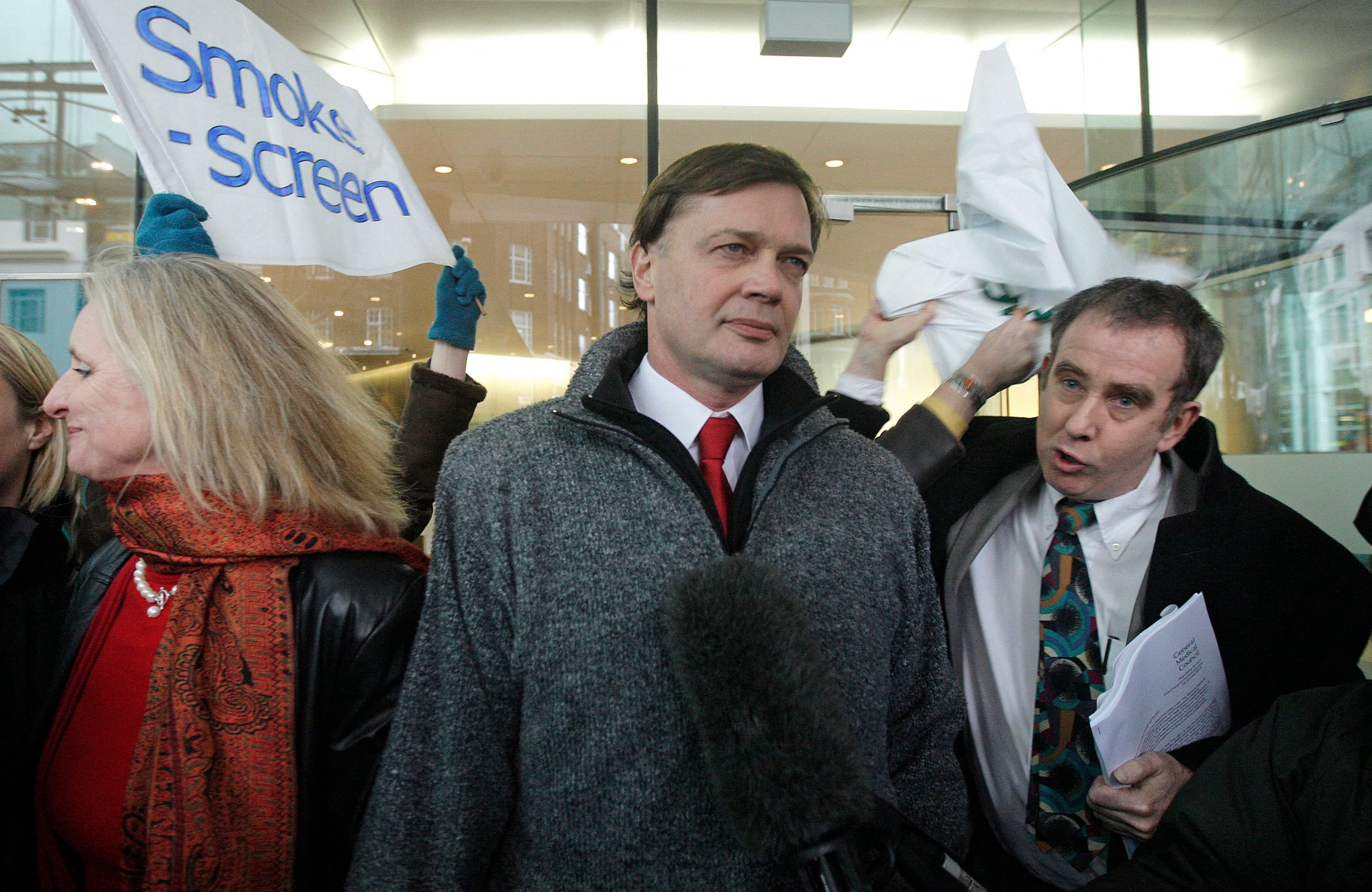 British investigative reporter Brian Deer (R) confronts British Doctor Andrew Wakefield (C) as he arrives with his wife Carmel (L) at the General Medical Council (GMC) in central London, on January 28, 2010. The doctor who sparked the MMR controversy "showed a callous disregard" for the suffering of children and "abused his position of trust", a disciplinary panel ruled on Thursday. Dr Andrew Wakefield's conduct brought the medical profession "into disrepute" after he took blood samples from youngsters at his son's birthday party in return for payments of £5. AFP PHOTO/SHAUN CURRY (Photo by SHAUN CURRY / AFP)