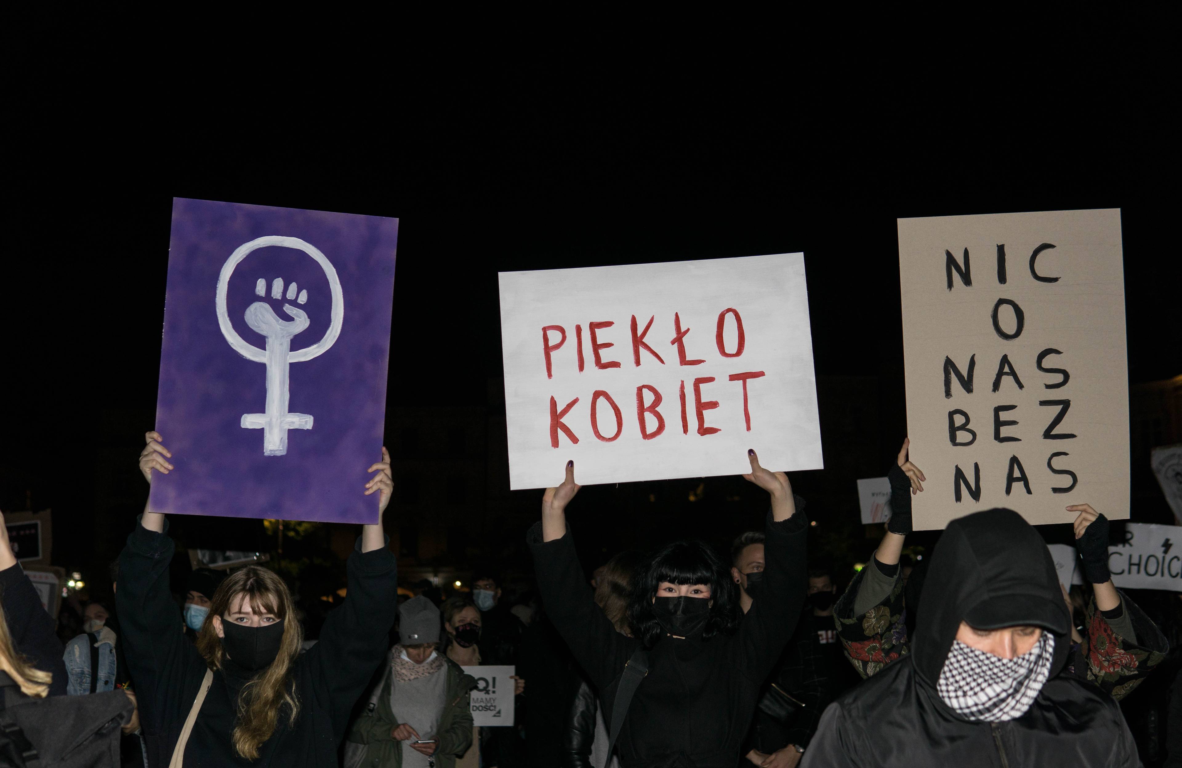 Kobiety trzymają karton z napisem "piekło kobiet"