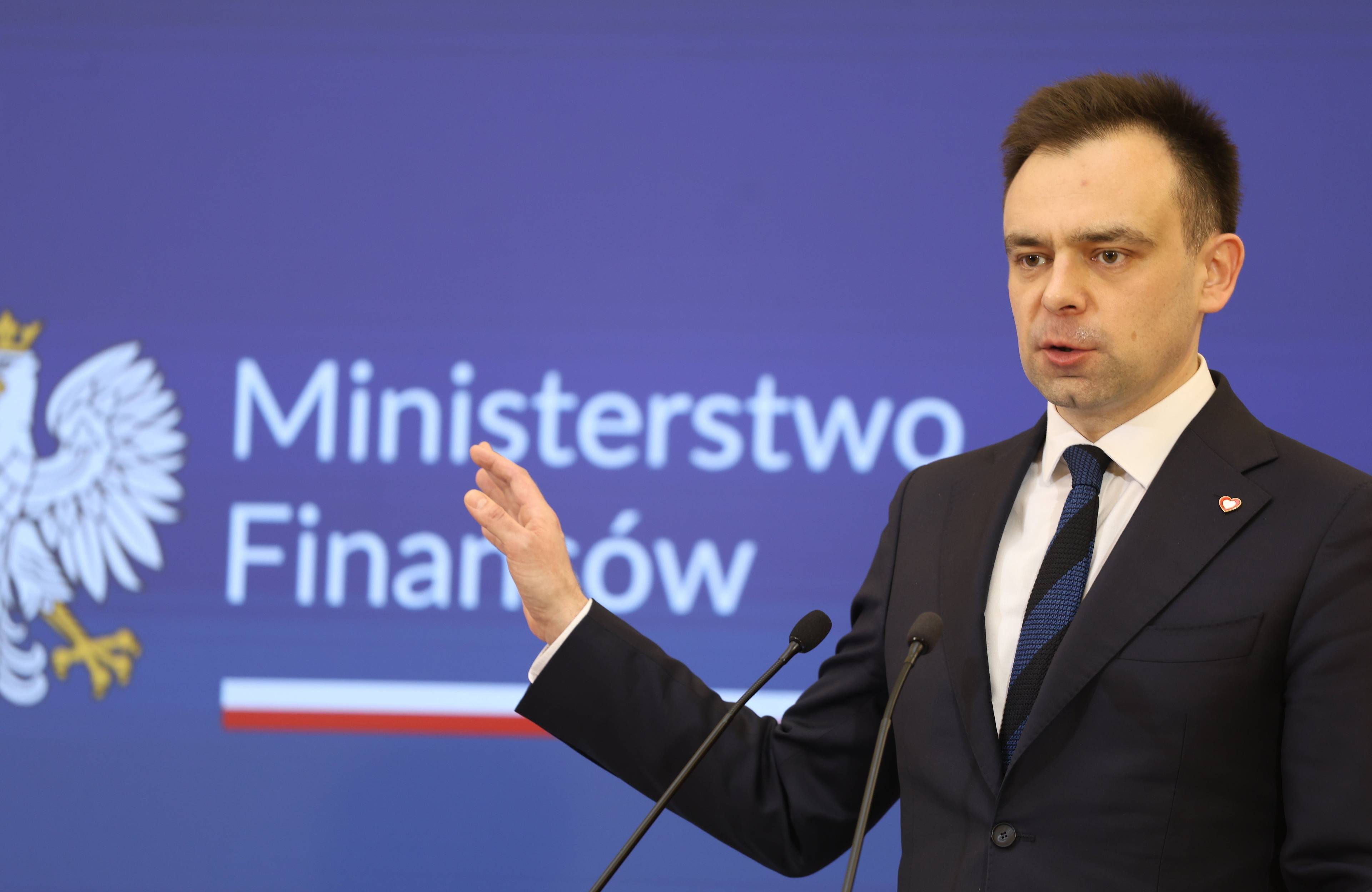 Andrzej Dońaski gestykuluje na tle napisu Ministerstwo Finansów