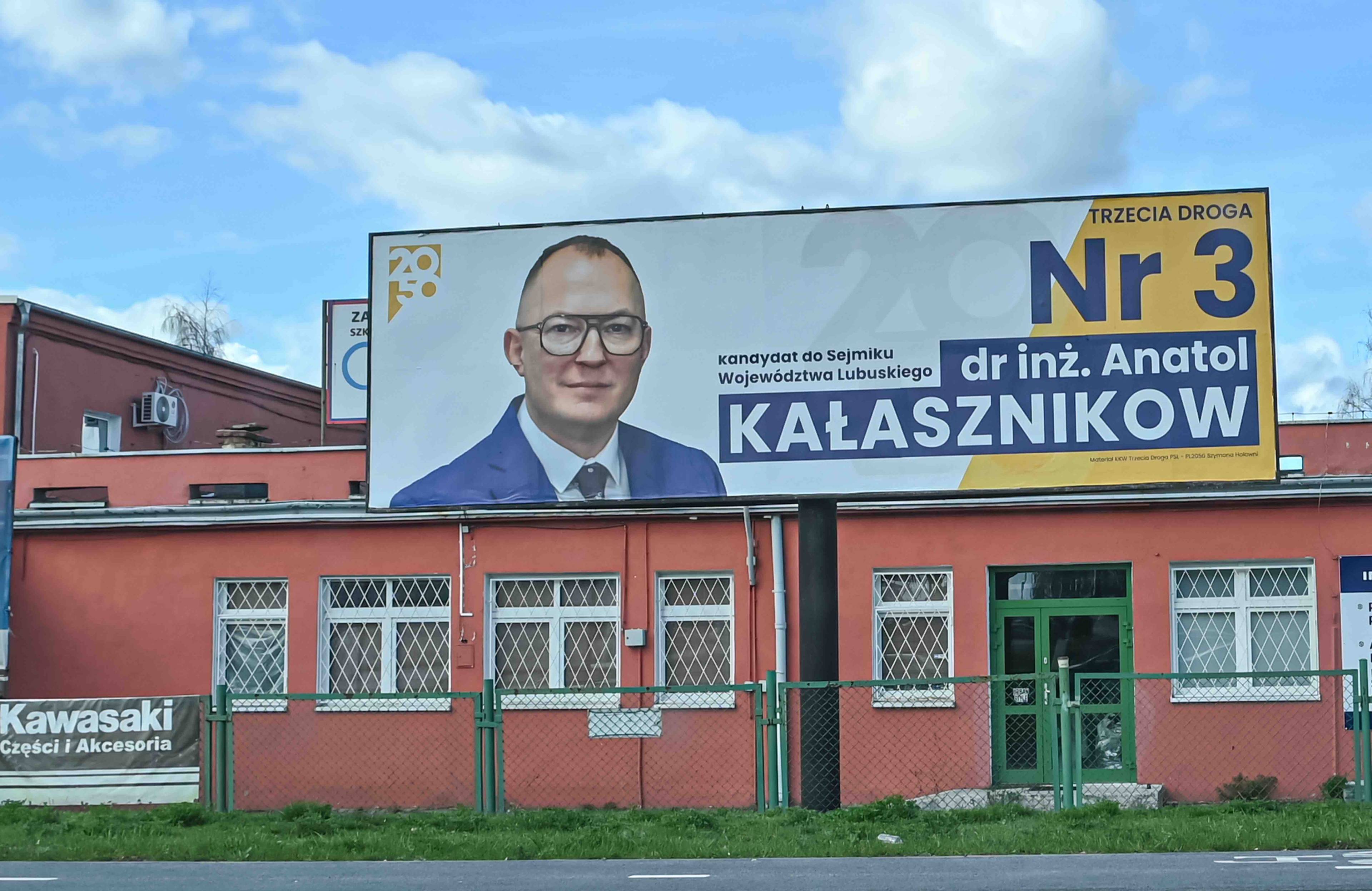 Baner wyborczy, zdjęcie kandydata o nazwisku Kałasznikow, startującego z listy Trzeciej Drogi. Samorząd