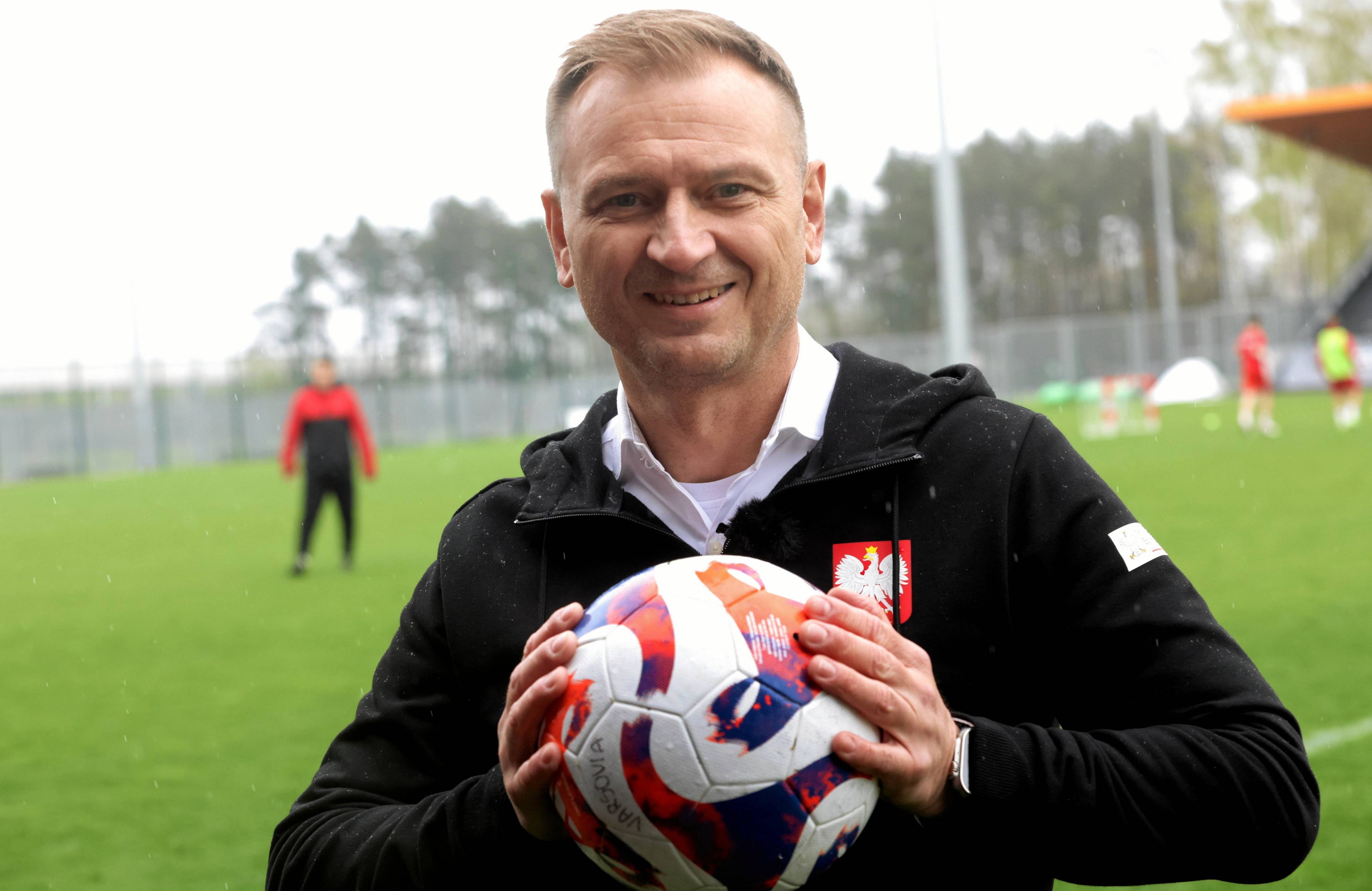 Minister sportu Sławomir Nitras ściska piłkę do piłki nożnej