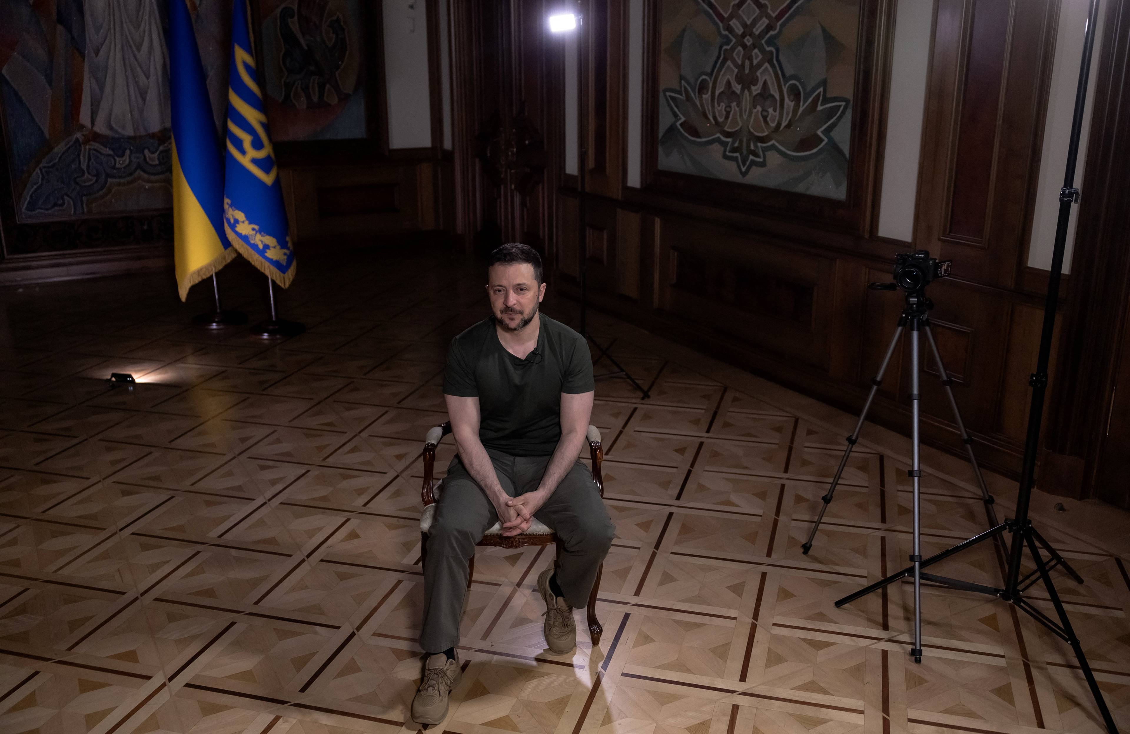 Prezydent Zełenski siedzi na krześle w pustym pokoju