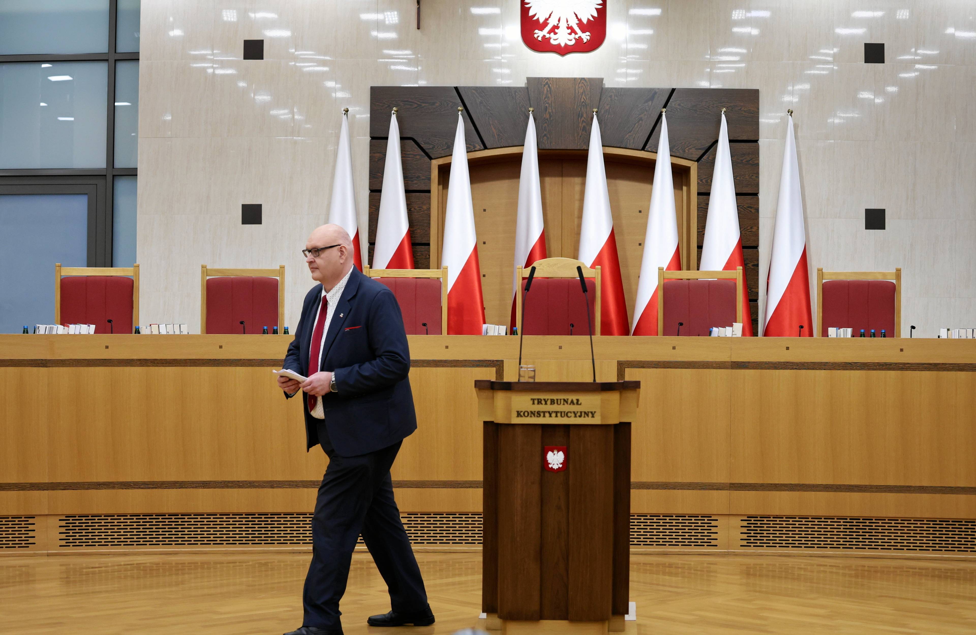 Duży, otyły mężczyzna wychodzi z sali