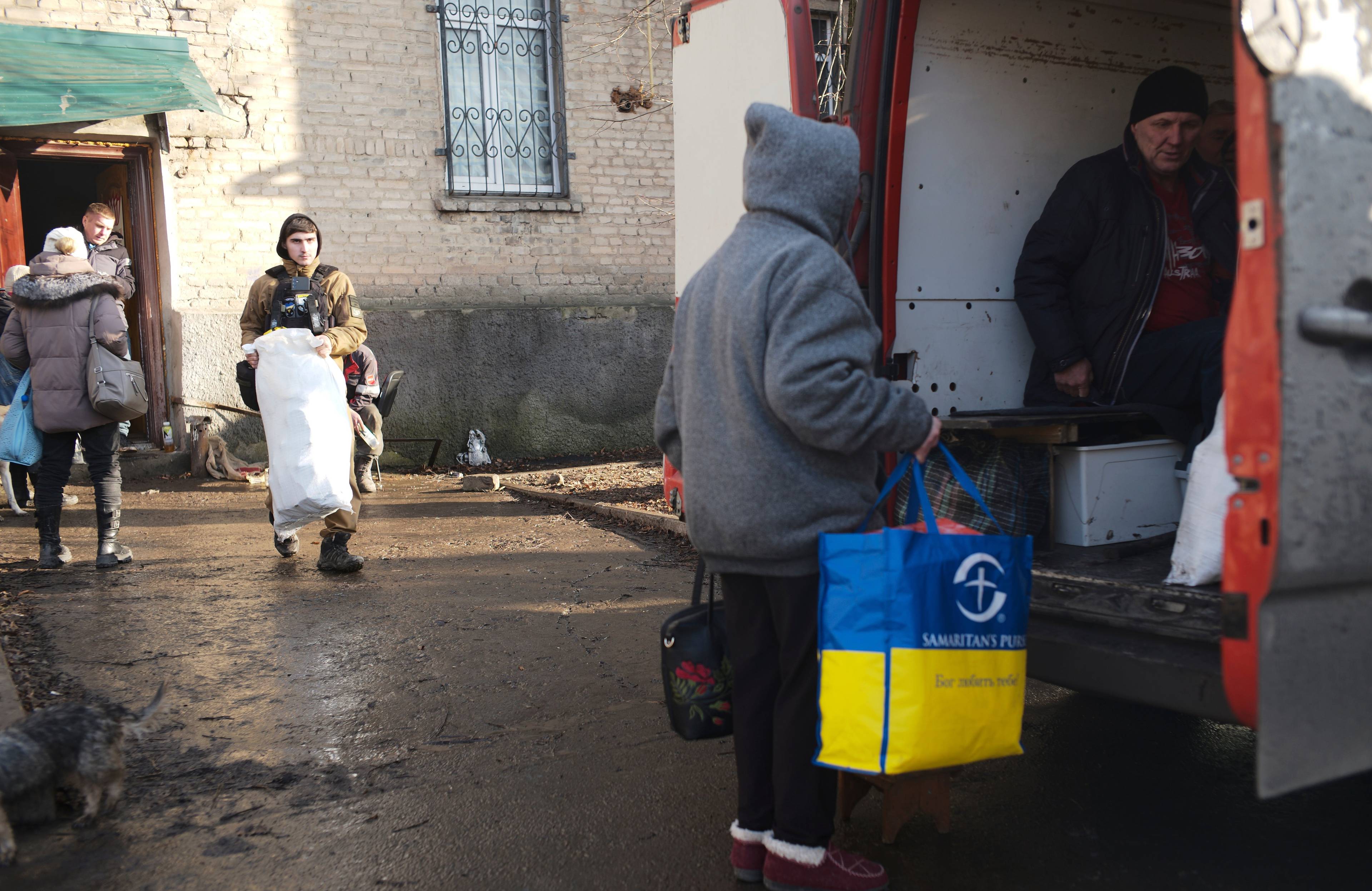 Meżczyżczyzna z torbą w kolorach flagi Ukrainy wsiada do ciężarówki