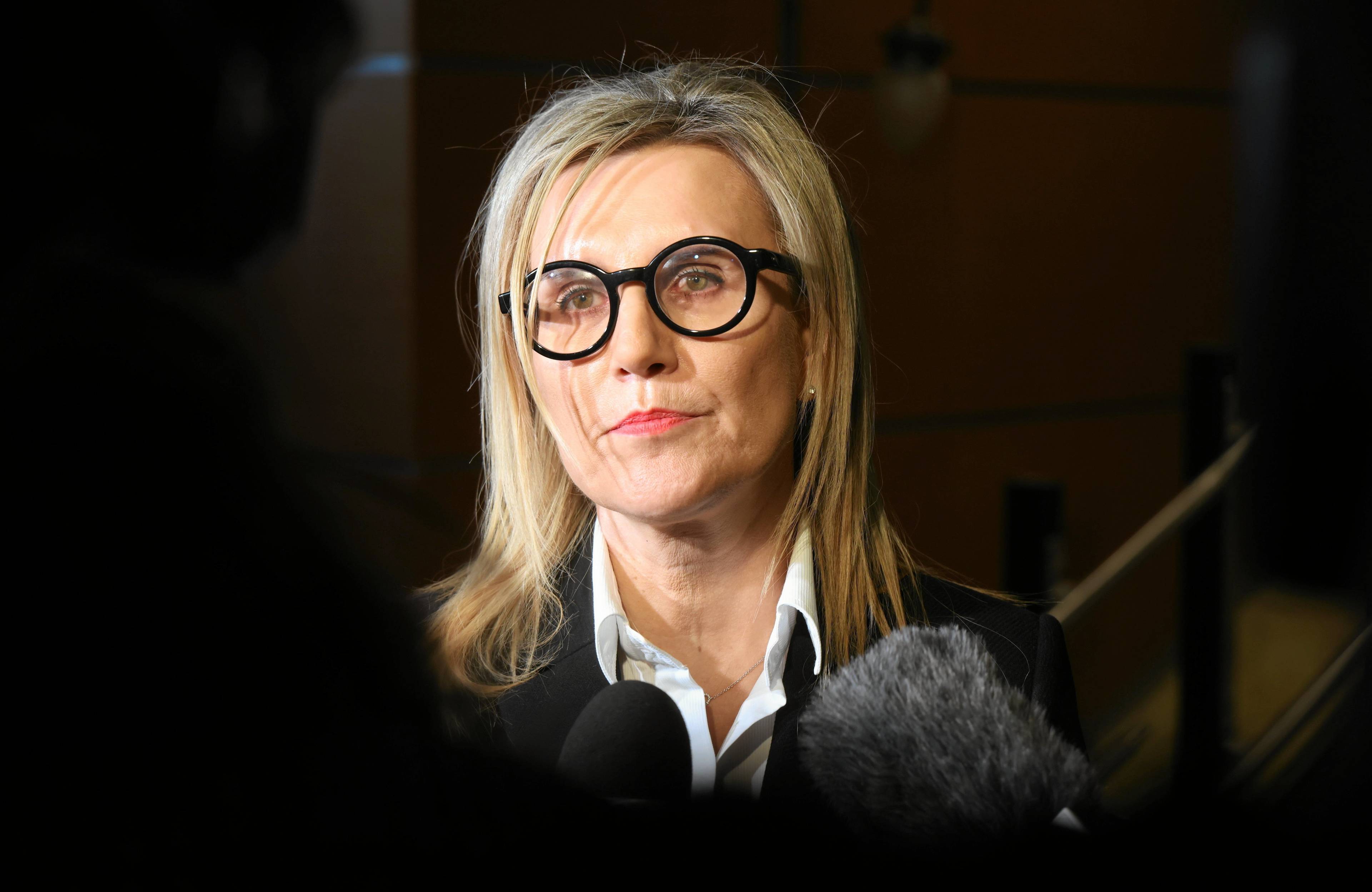 Na zdjęciu widać kobietę w okulrach (prokurator Ewa Wrzosek) stojącą przed mikrofonami mediów