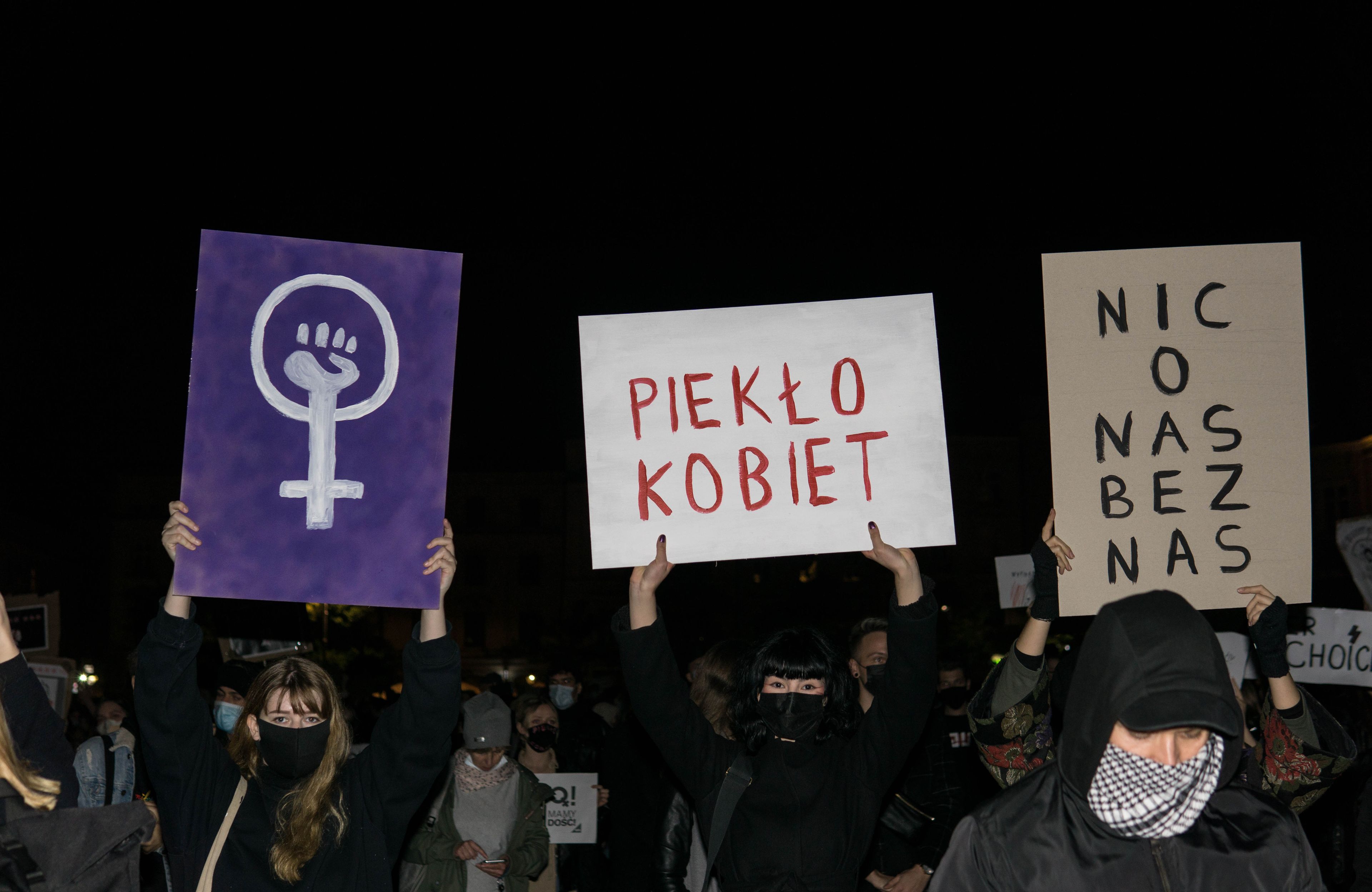 Kobiety trzymają karton z napisem "piekło kobiet"