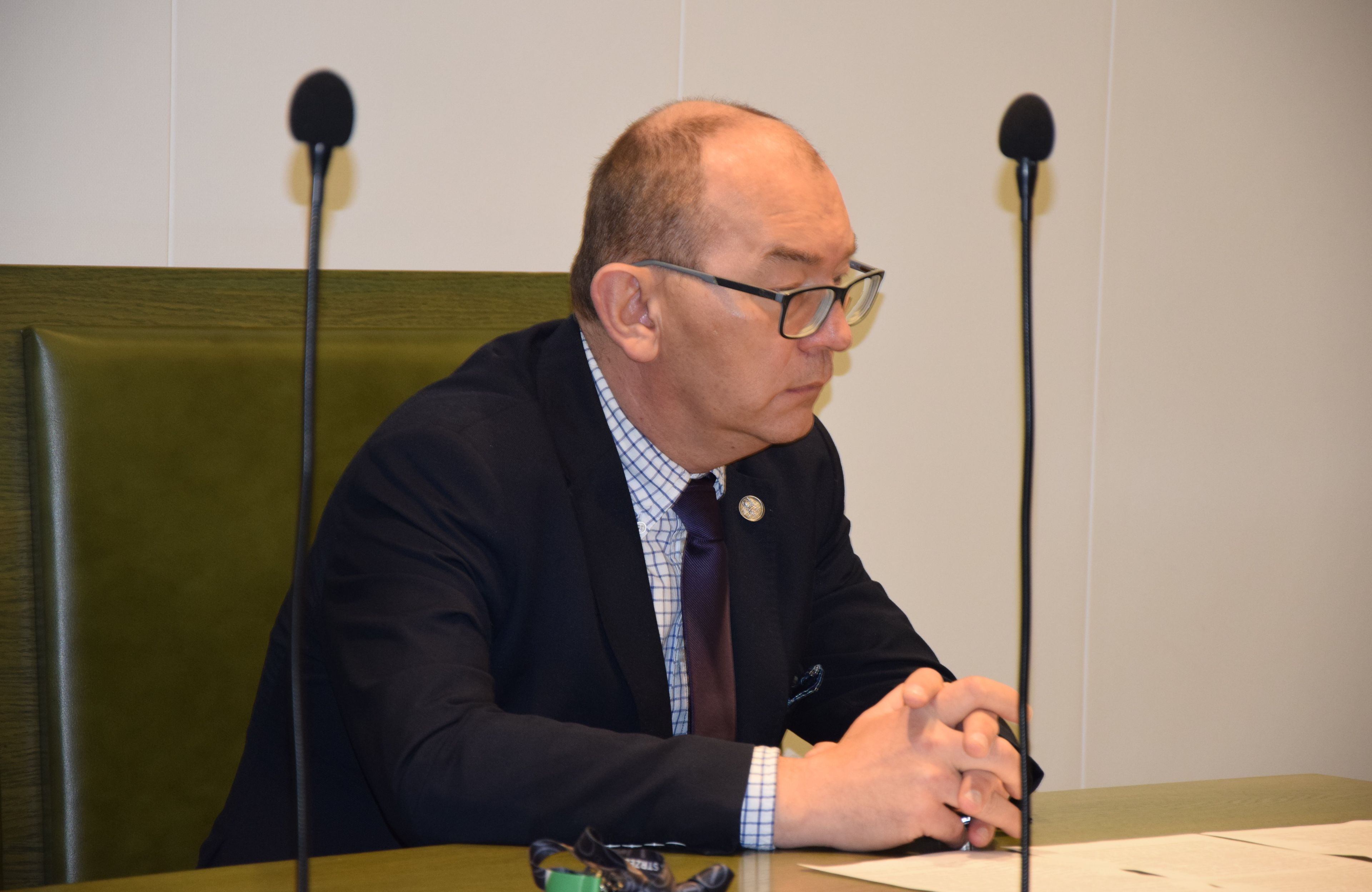 Mężyzna w okularach siedzi za stołem