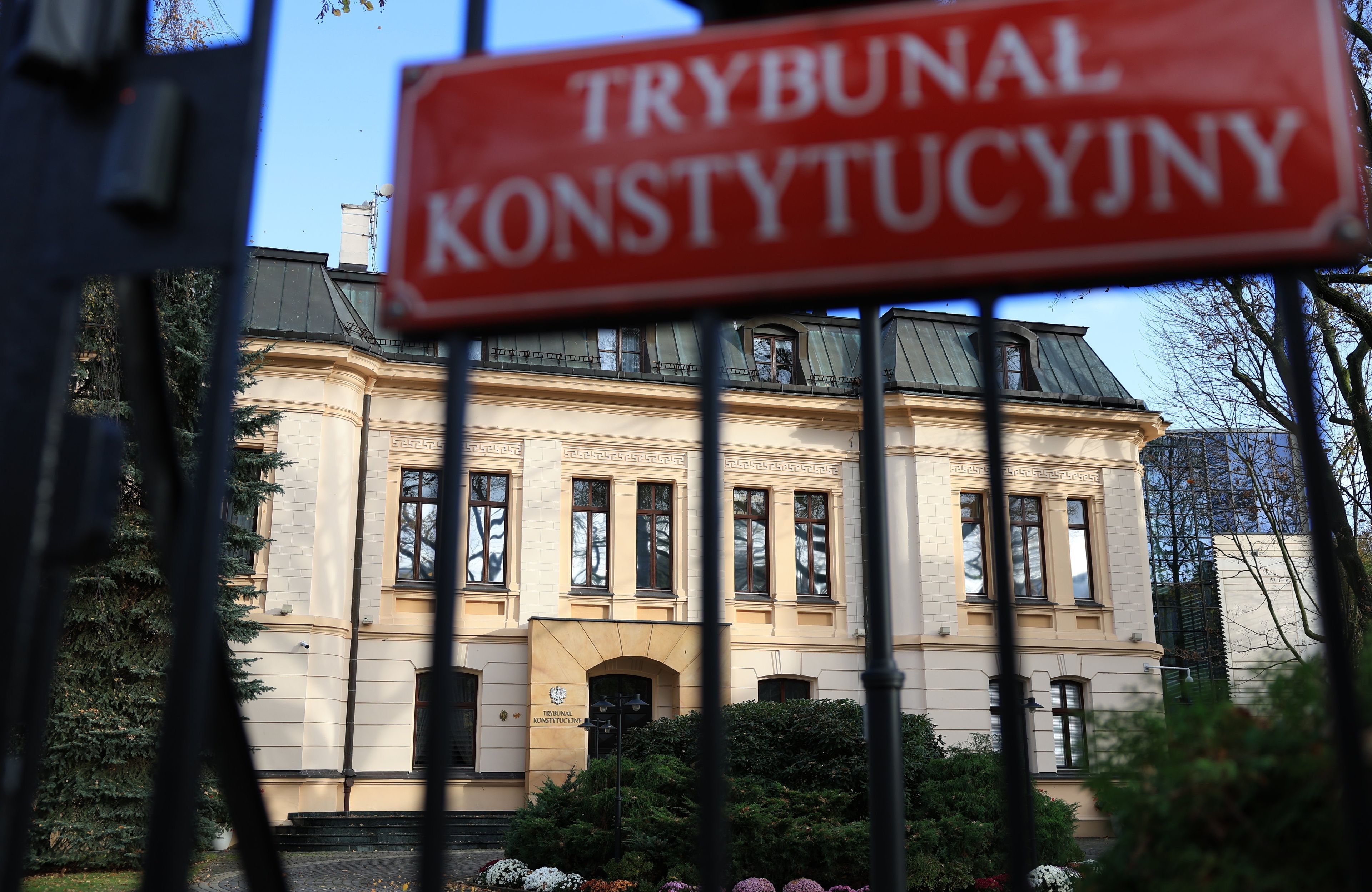 Tablica z napisem Trybunał Konstytucyjny na płocie , w tle budynek TK