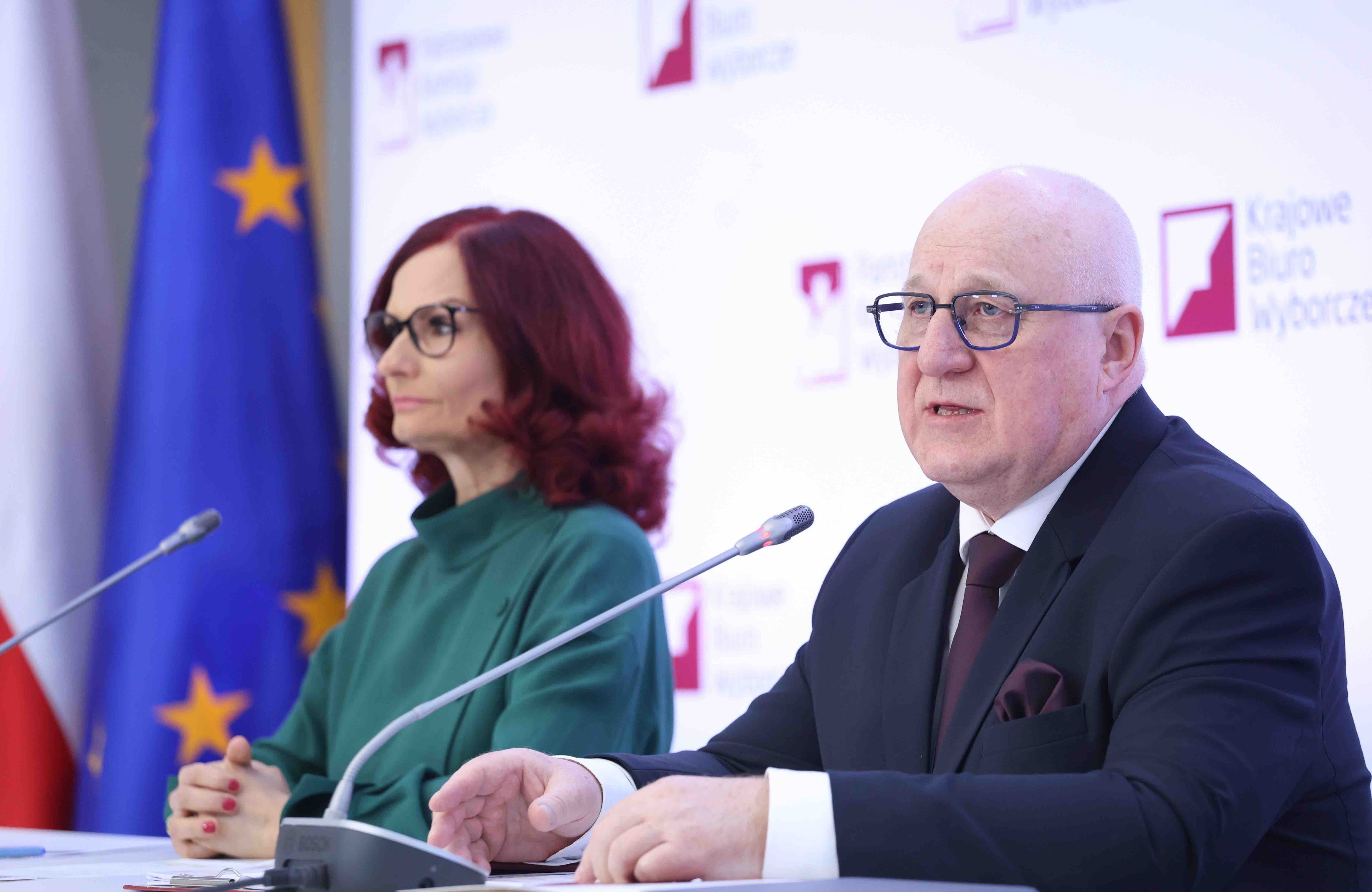Kobieta i mężczyzna siedzą przy stole podczas konferencji prasowej . Państwowa Komisja Wyborcza