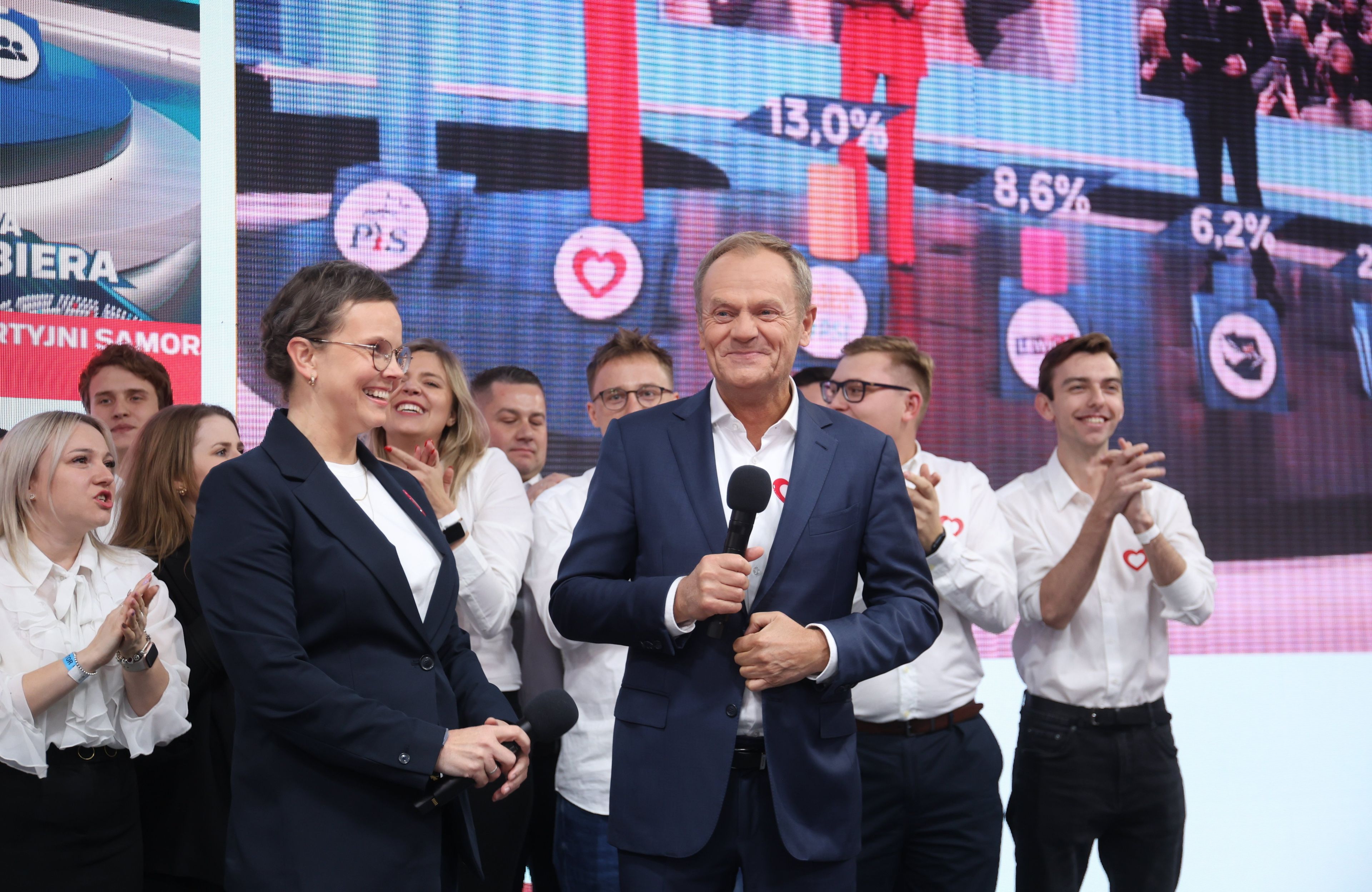 Uśmiechnięta kobieta obok Donalda Tuska