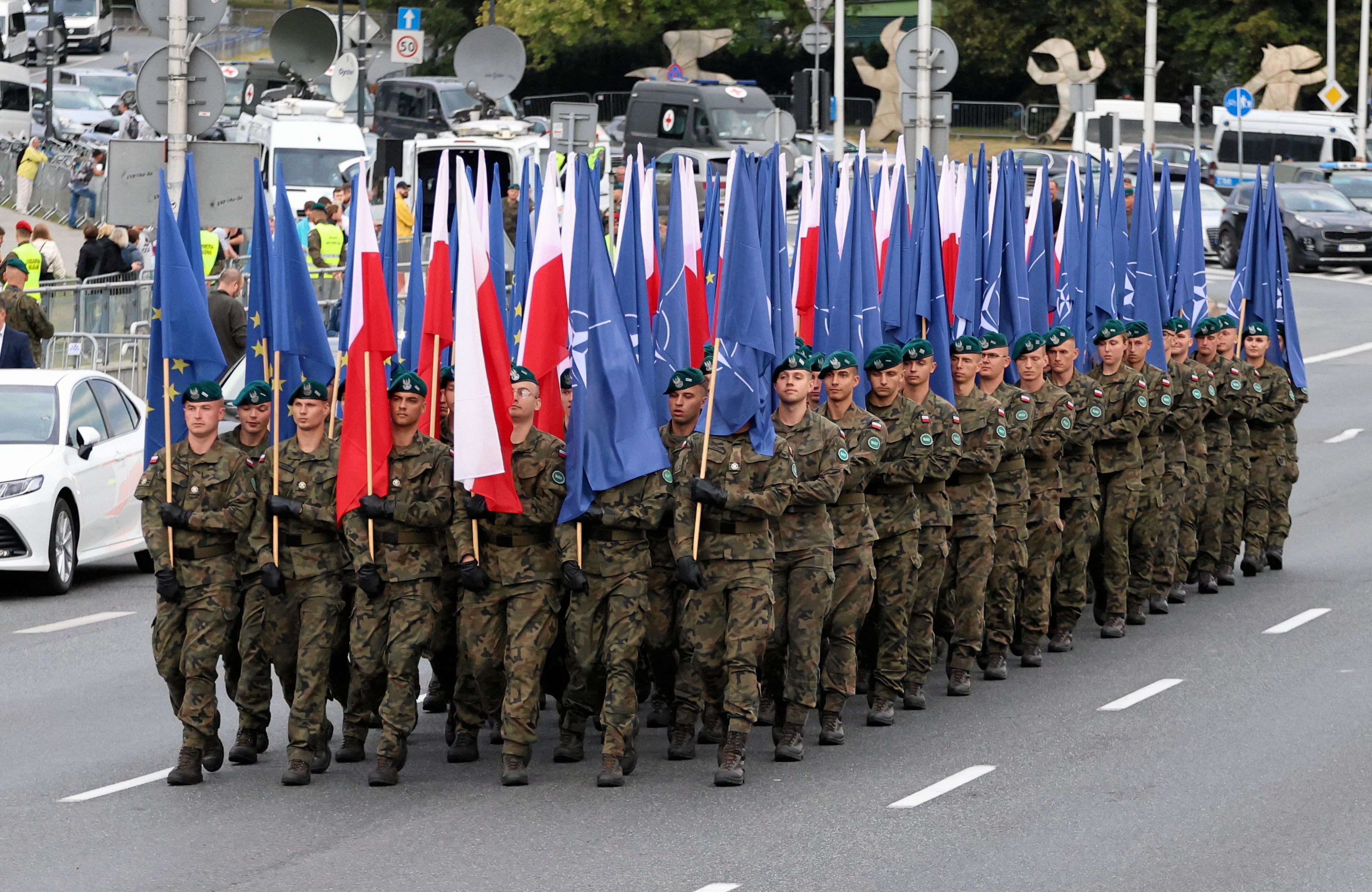 Kolumna wojskowej piechoty z flagami polskimi, Unii Europejskiej i NATO