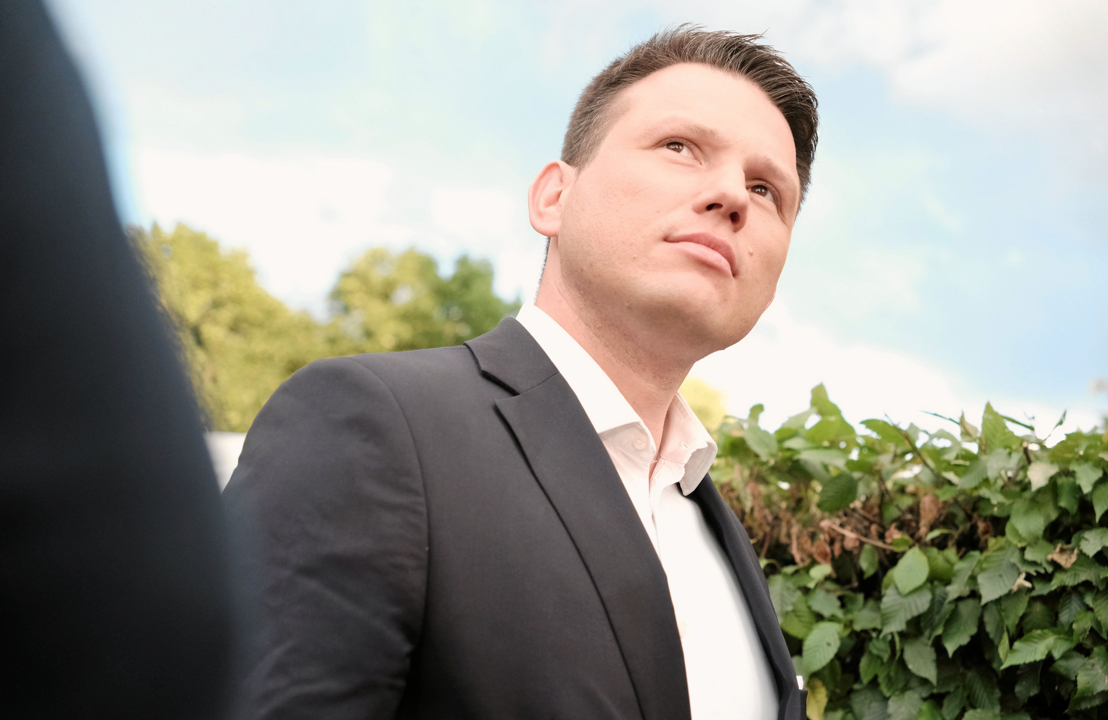 Lider Konfederacji Sławomir Mentzen stoi z przekrzywioną głową
