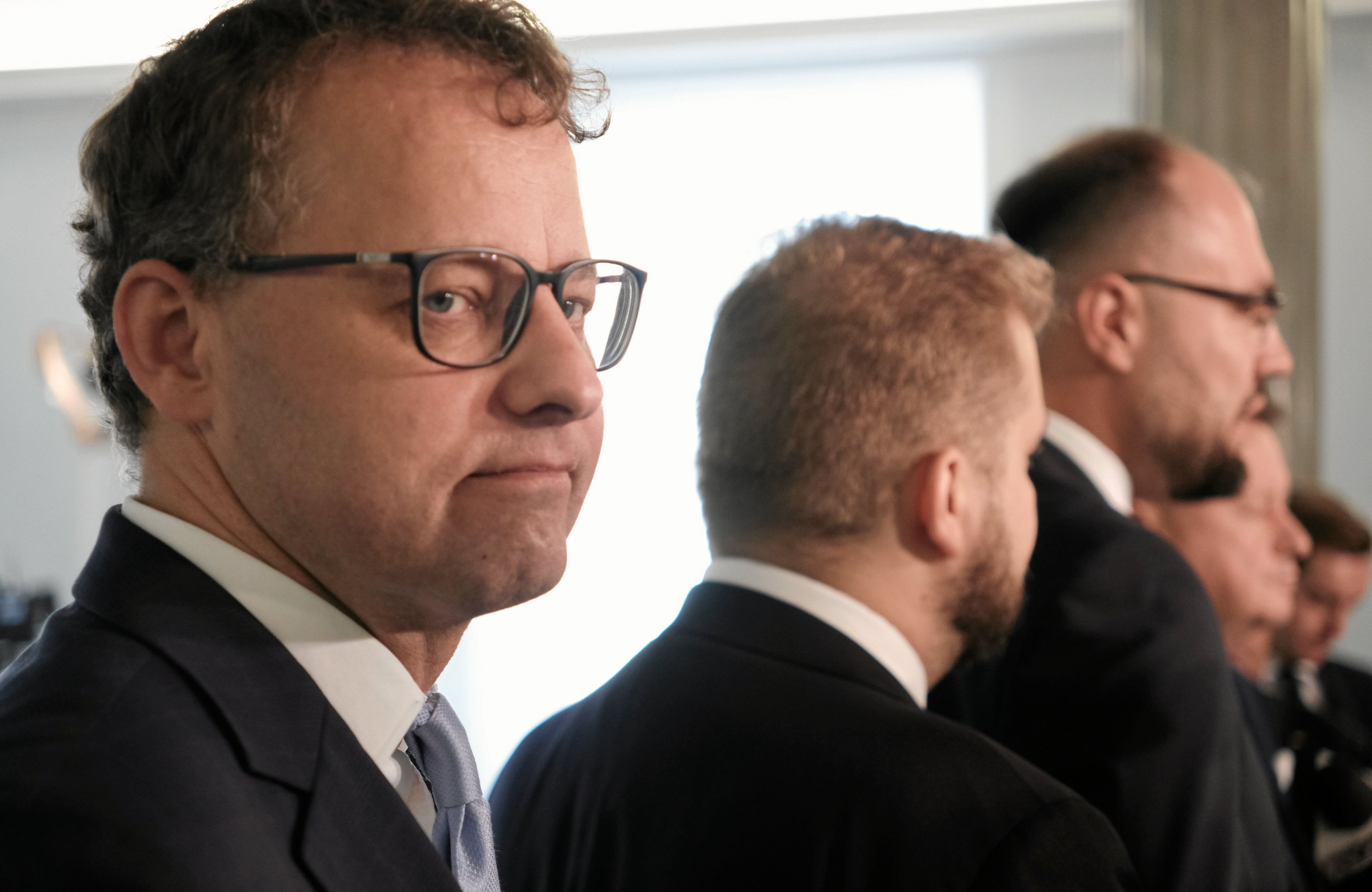 Mężczyzna w okularach z opuszczonymi kącikami ust, raczej smutny