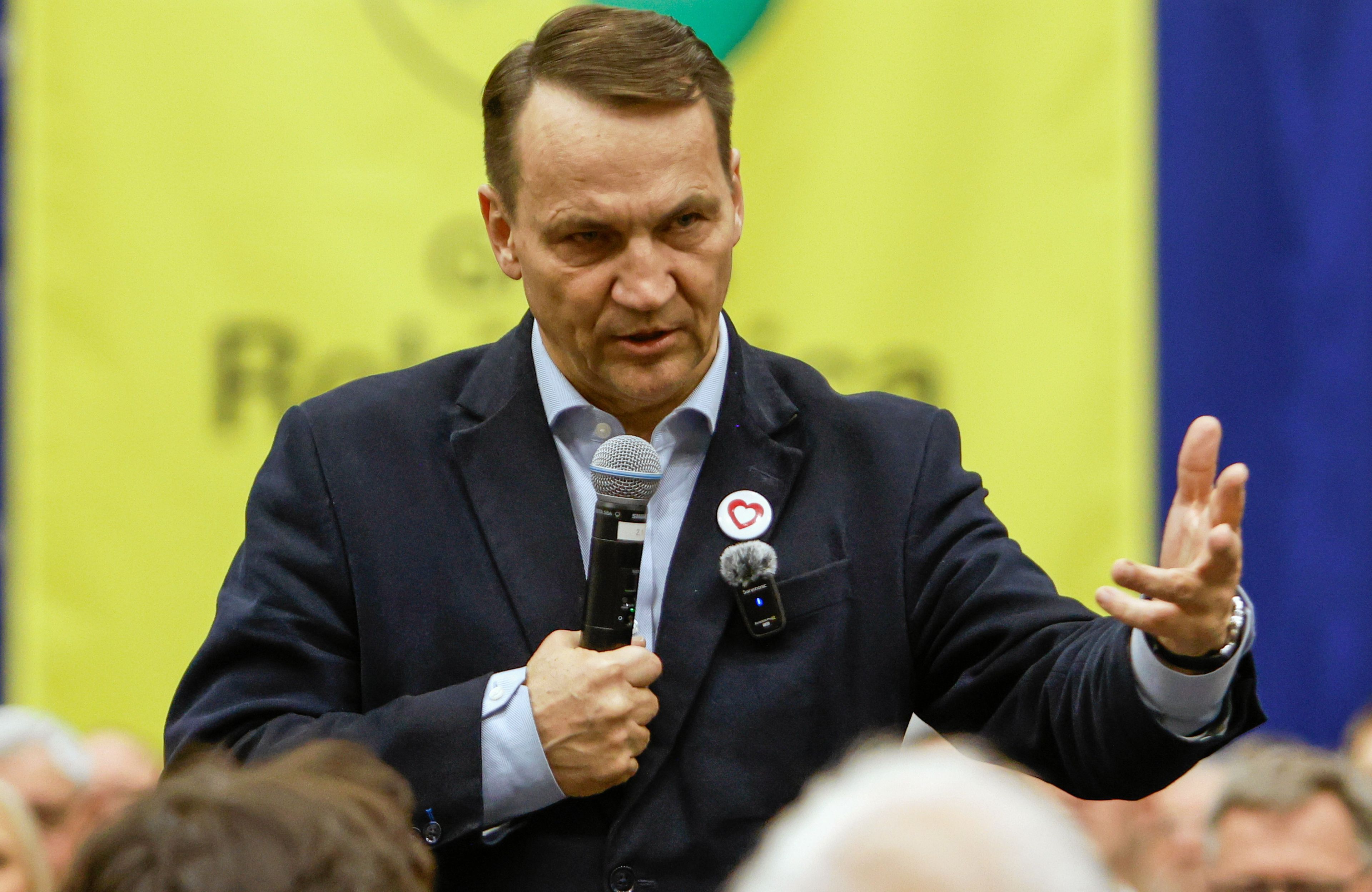 Mężczyzna z mikrofonem i poważną miną