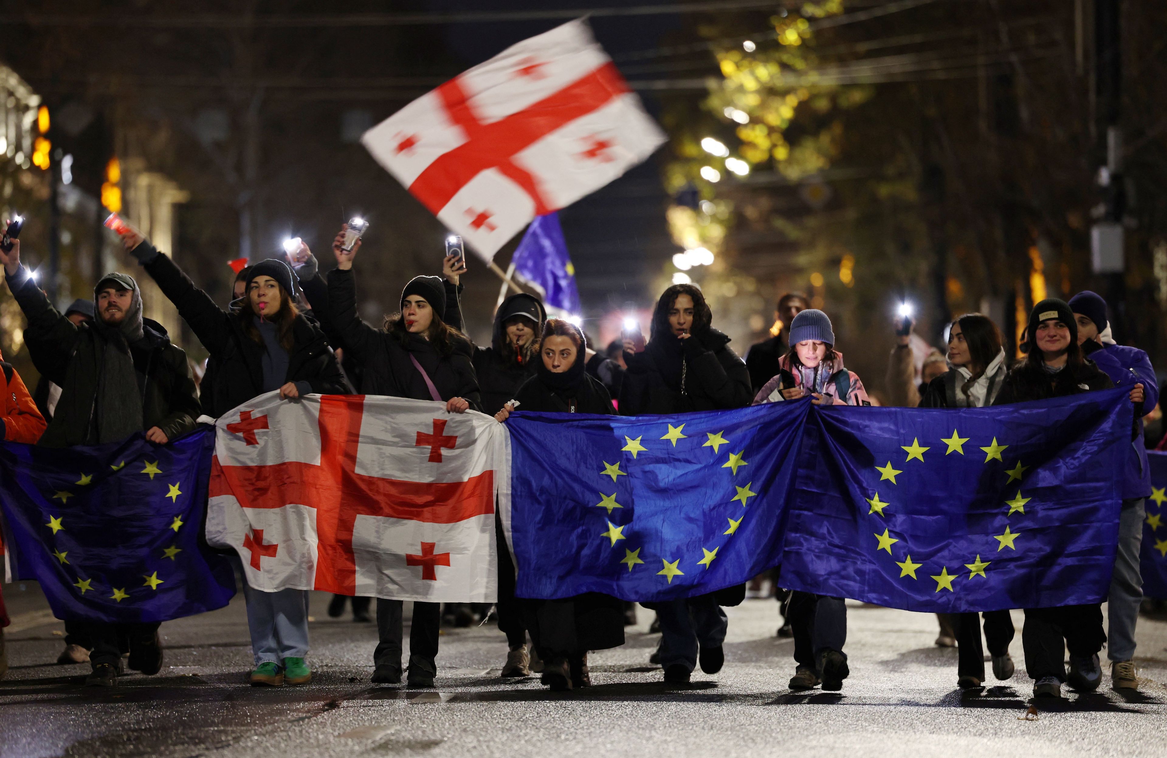protestujący z flagami ue i gruzji
