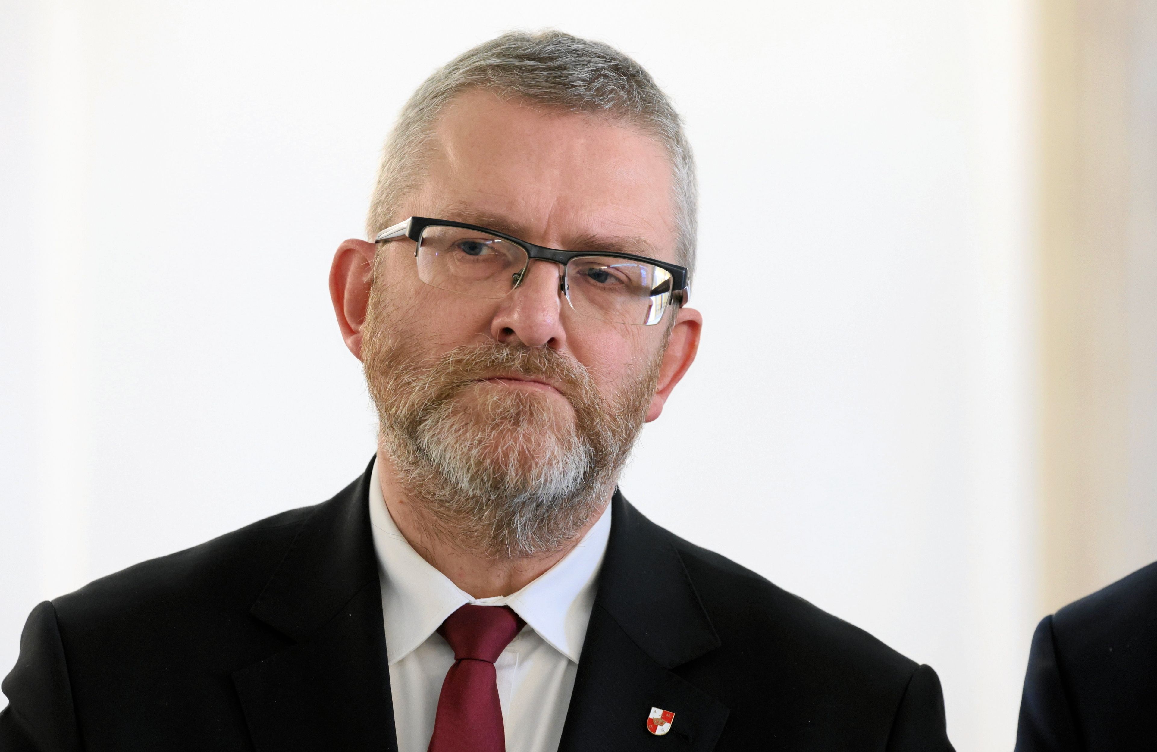 Brodaty mężczyzna w okularach, garniturze i bordowym krawacie (Grzegorz Braun)