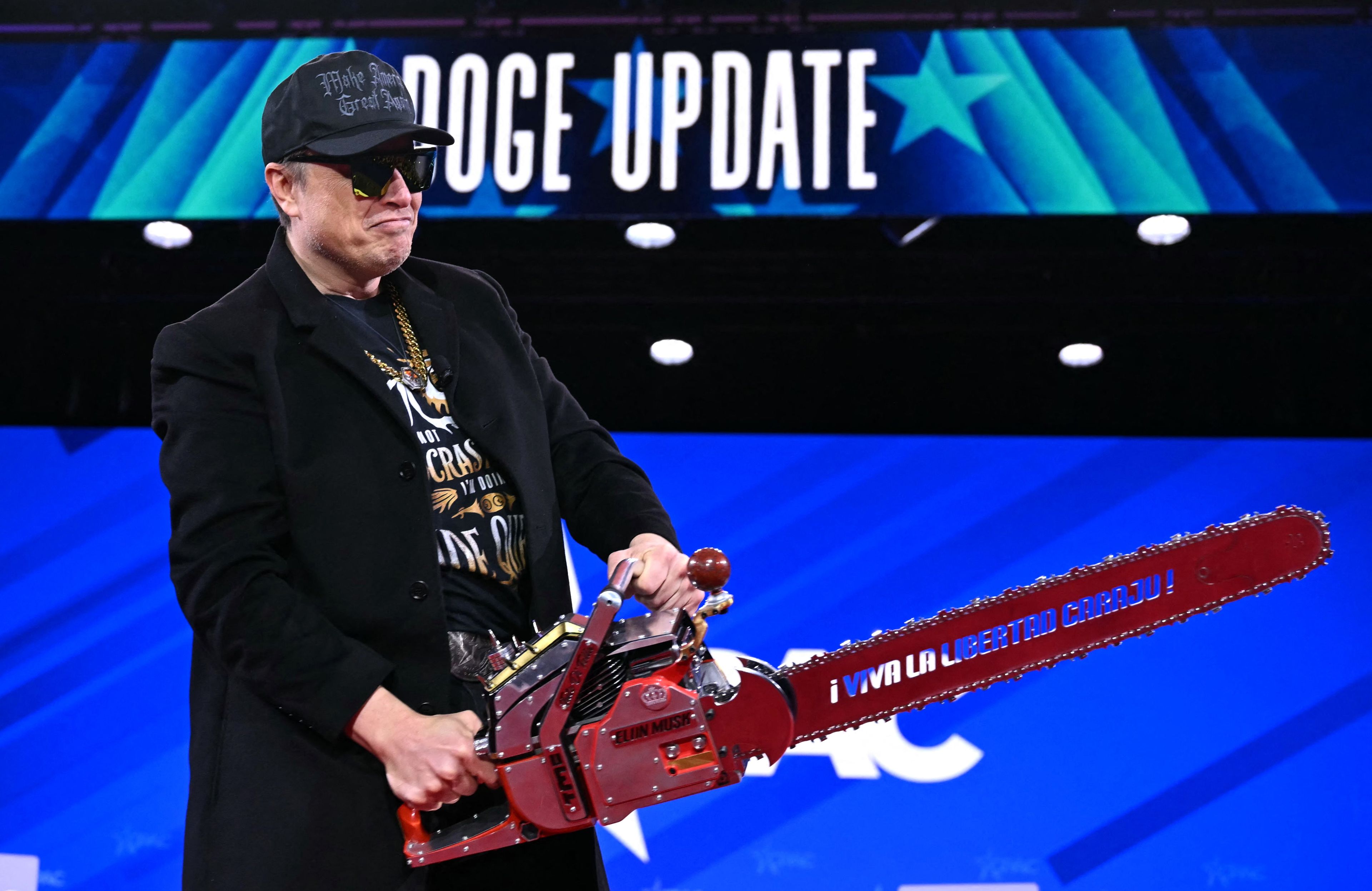 Elon Musk z piłą tarczową na scenie CPAC w Waszyngtonie, 20.02.2025 r.