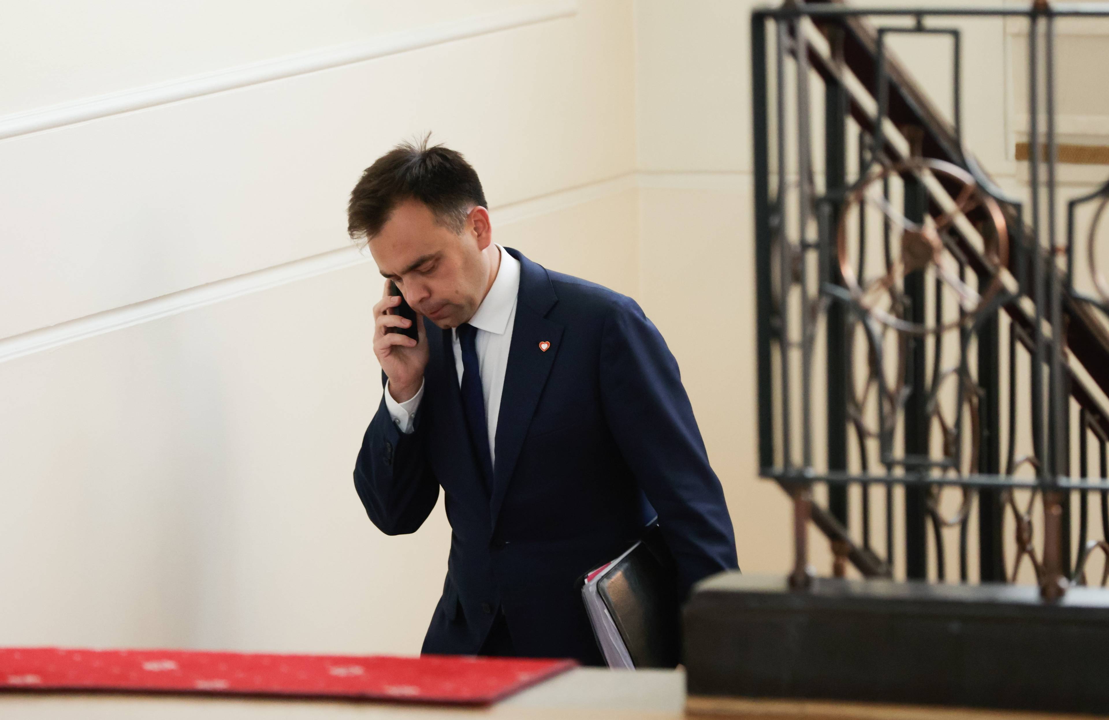 Minister Finansów Andrzej Domański na schodach sejmowych rozmawia przez telefon