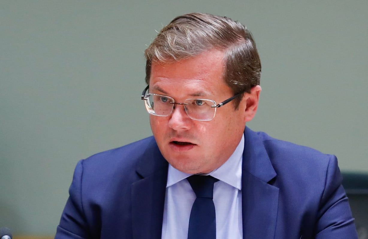 Andrzej Sadoś podczas posiedzenia Rady UE. Ubrany w niebieski garnitur i krawat oraz jasnoniebieską koszulę. Na twarzy okulary bez oprawek. Na stole przed nim mikrofon i tabliczka z napisem "Polska"
