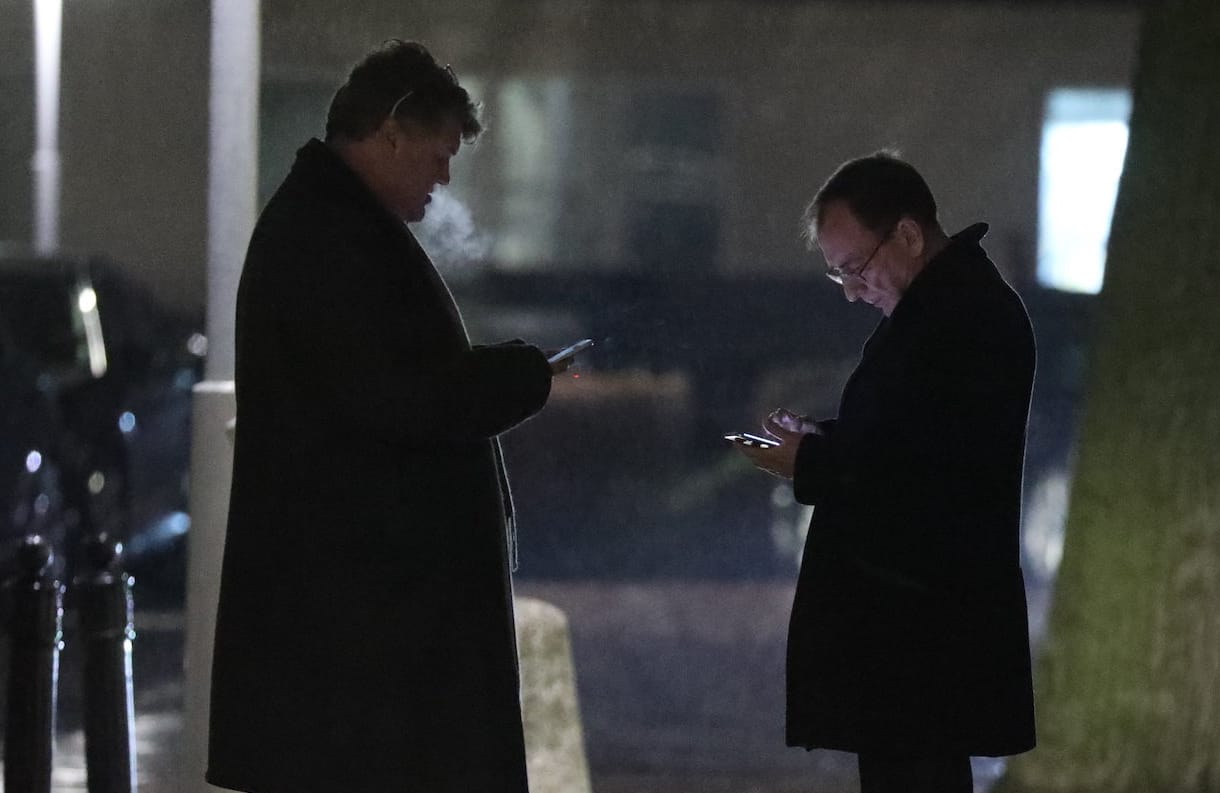 Dwaj mężczyźni w półmroku, w płaszczach na dworze