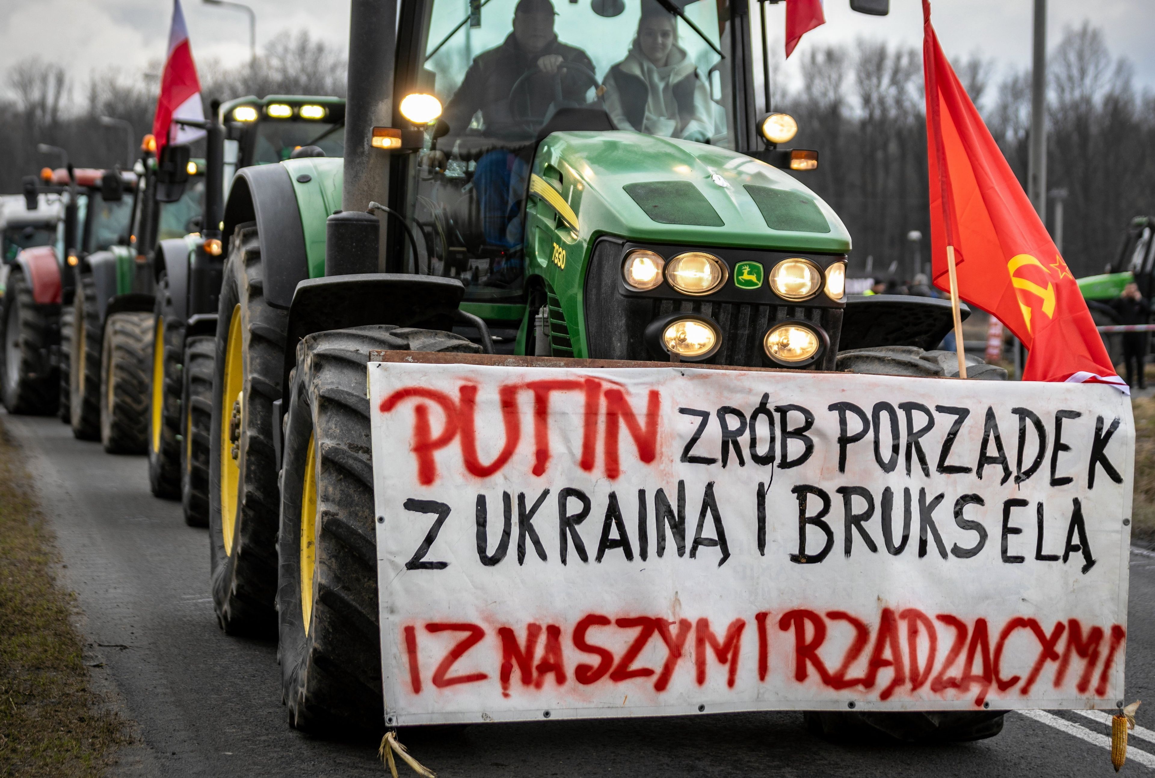 Traktor z przyczepionym z przudu banerem "Putin zr ób porządek z Ukrainą i Brukselą"