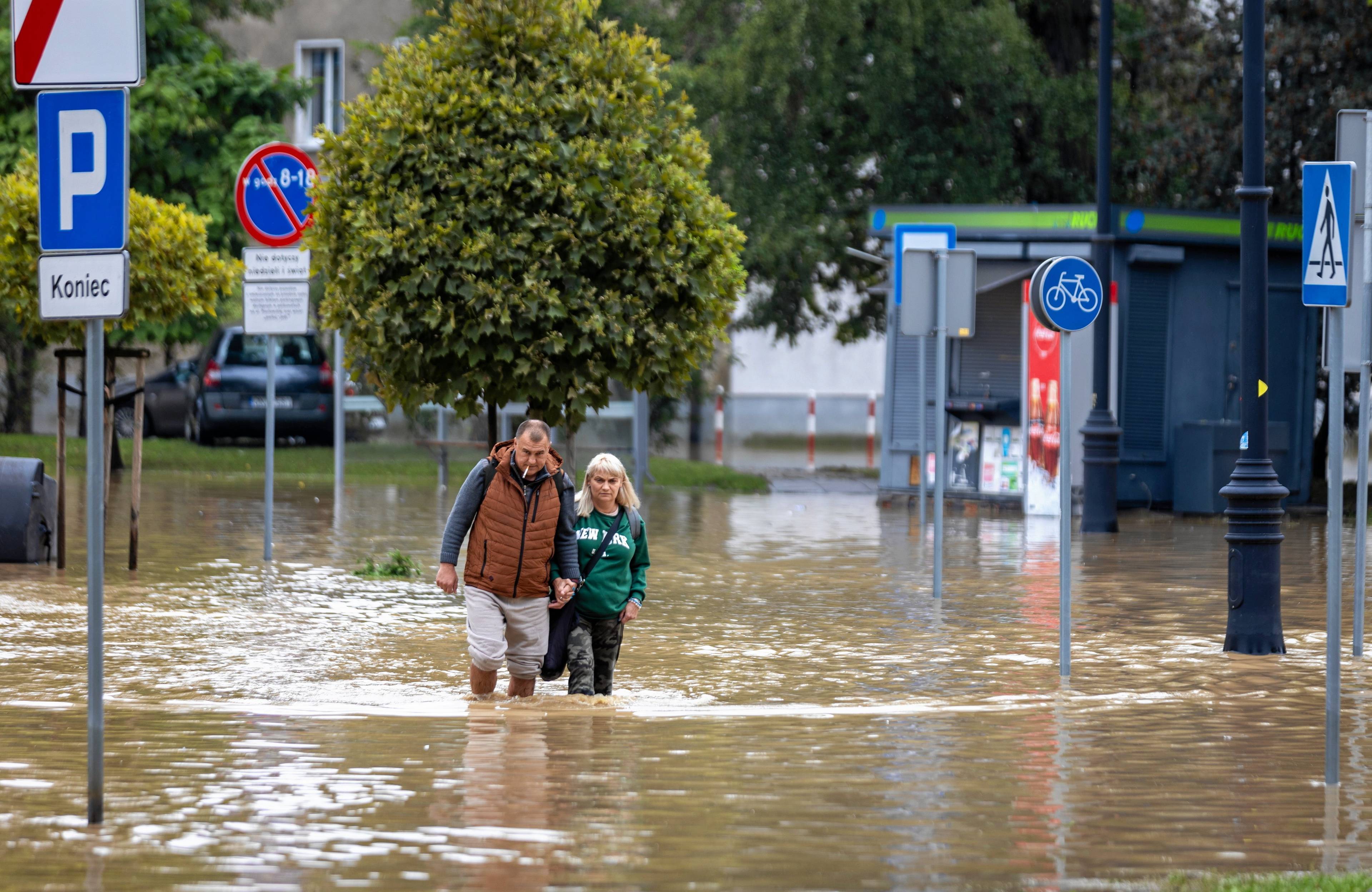 Miasto. Ludzie brodzą po kolana w wodzie