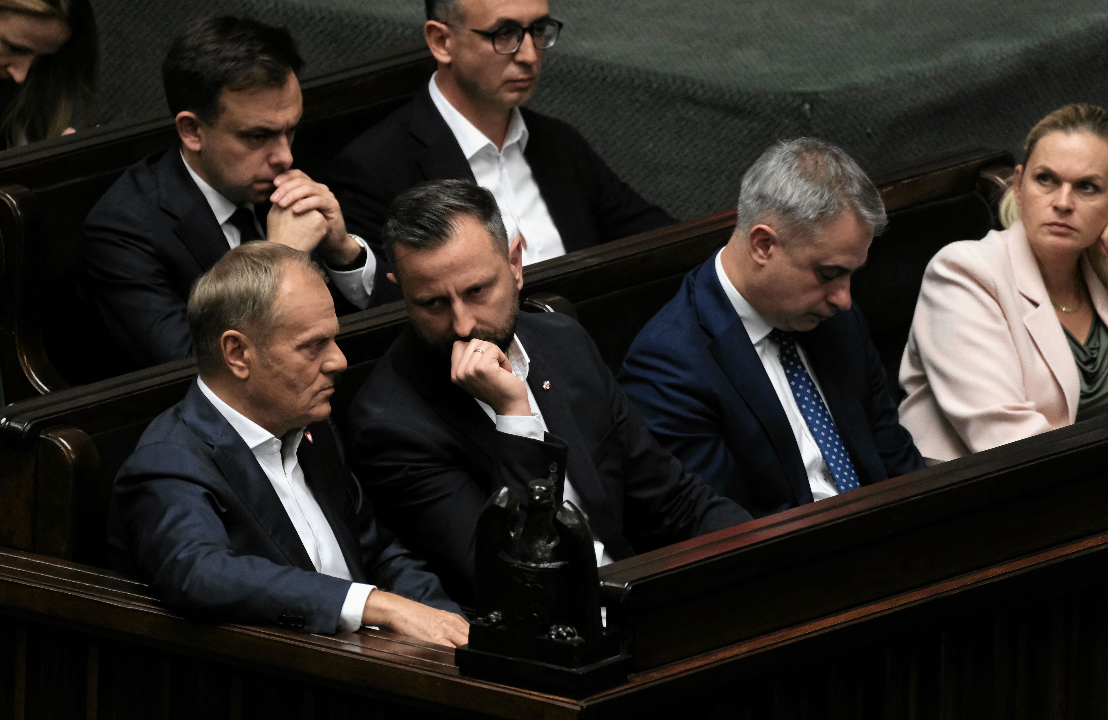 Grupa mężczyzn w dwóch ławkach i jedna kobieta