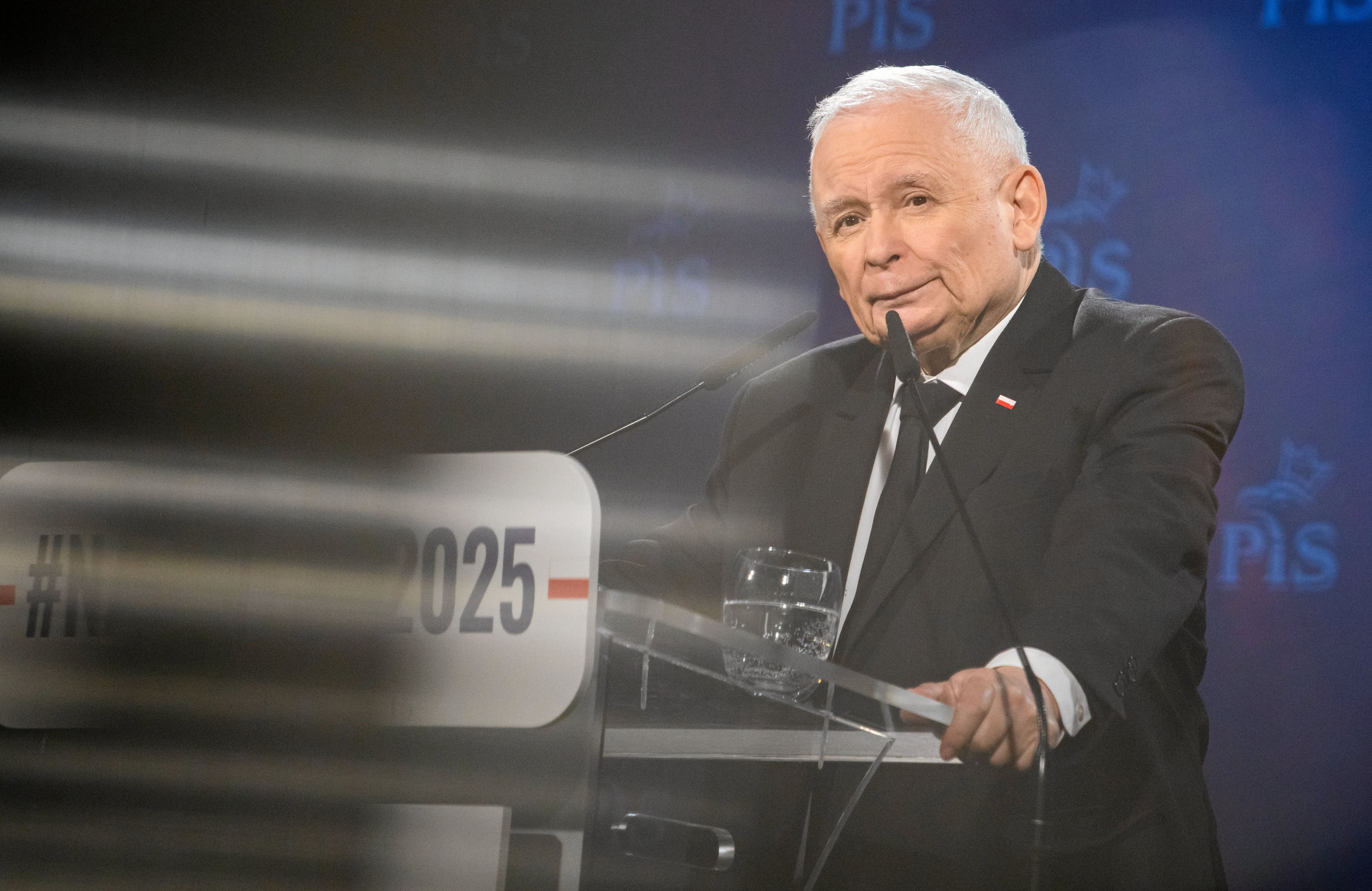 Starszy mężczyzna przemawia z trybuny na wiecu