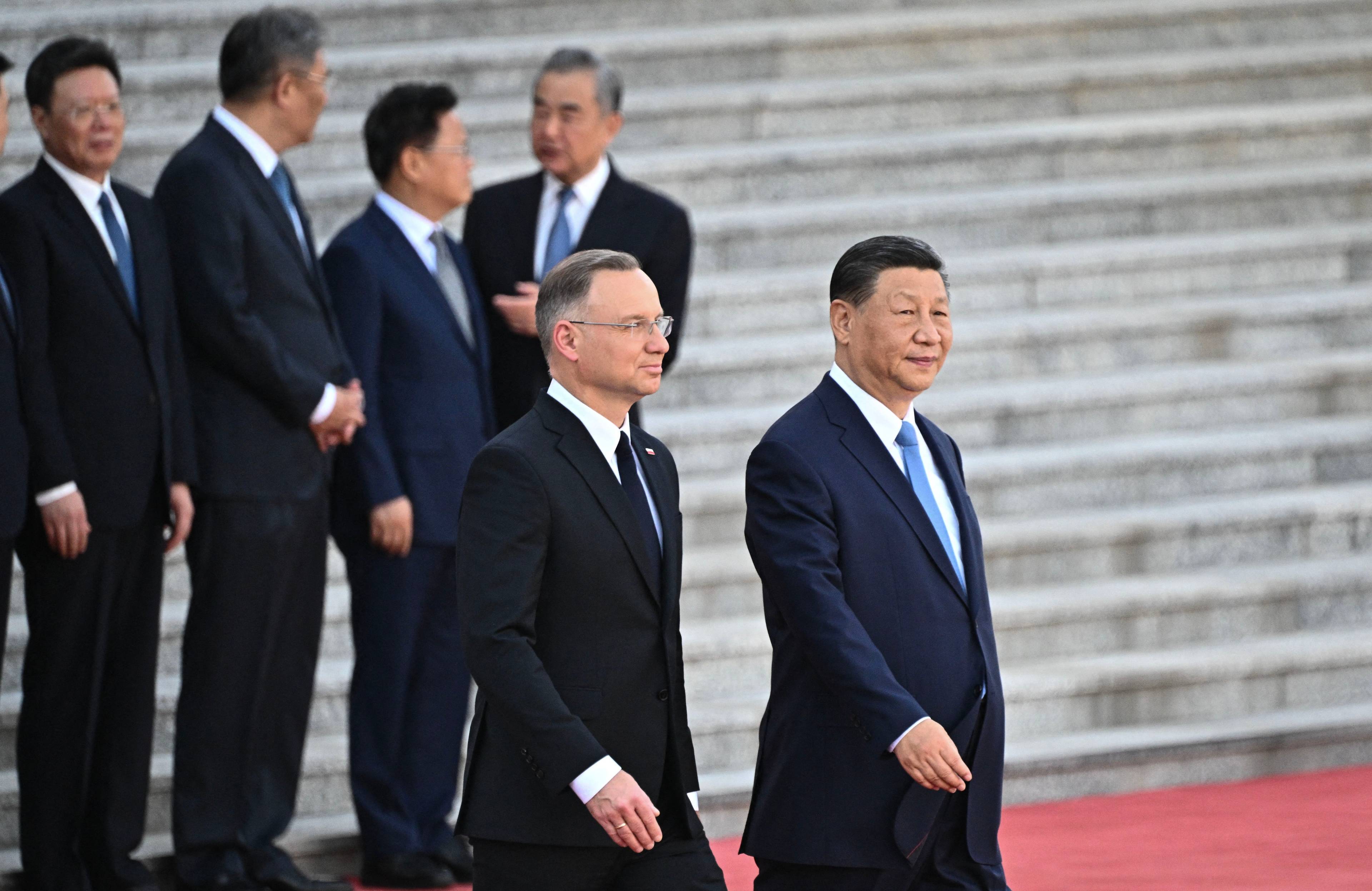 Prezydent Andrzej Duda i przewodniczący Chińskiej Republiki Ludowej Xi Jinping idą ramie w ramie na tle schodów