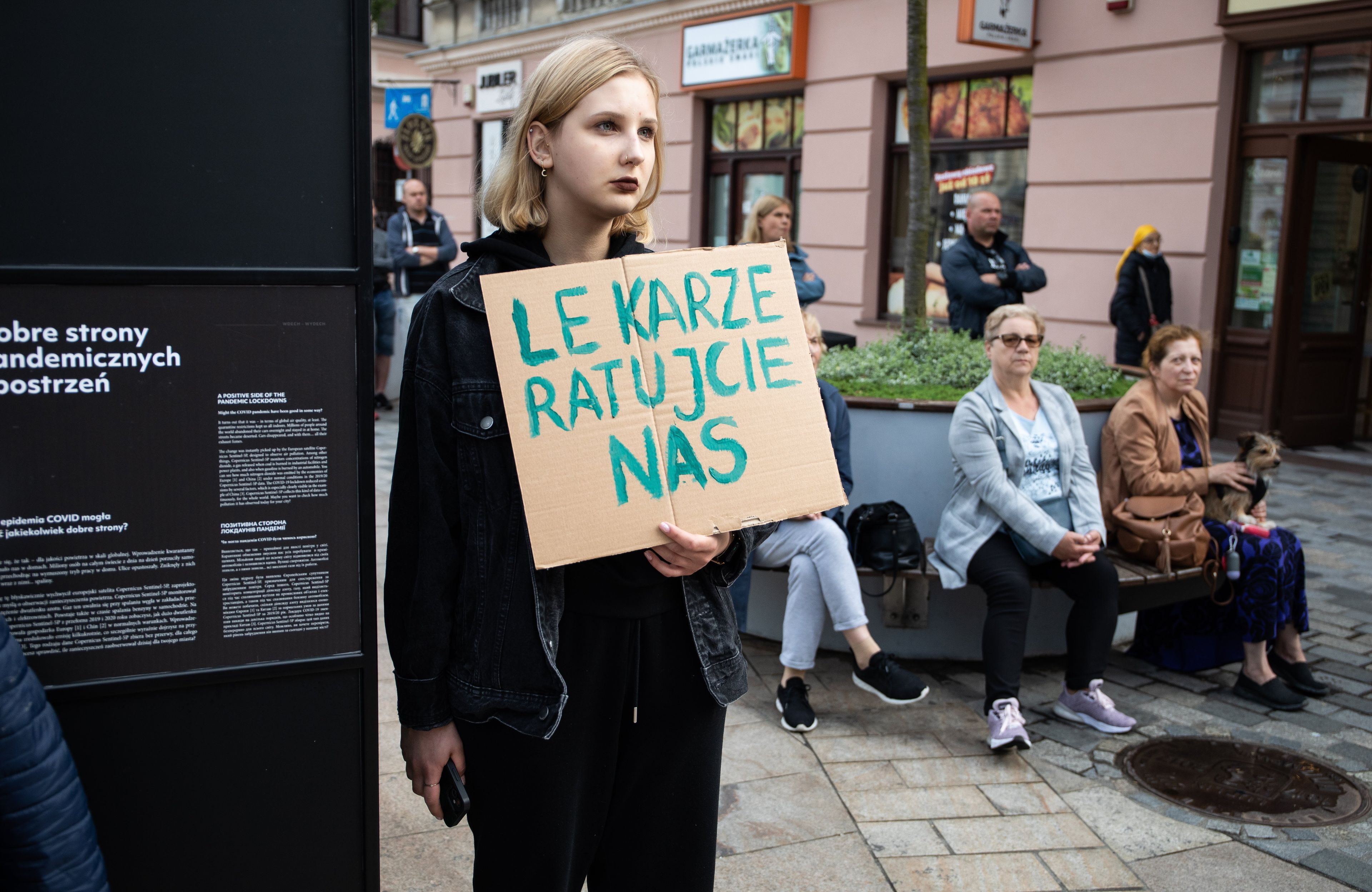 Kobieta z plakatem "Lekarze, ratujcie nas"