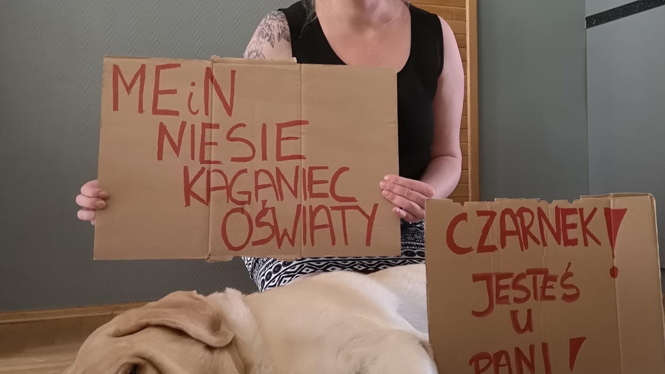 Agnieszka Jankowska-Maik z psem i kartką „MEiN niesie kaganiec oświaty"